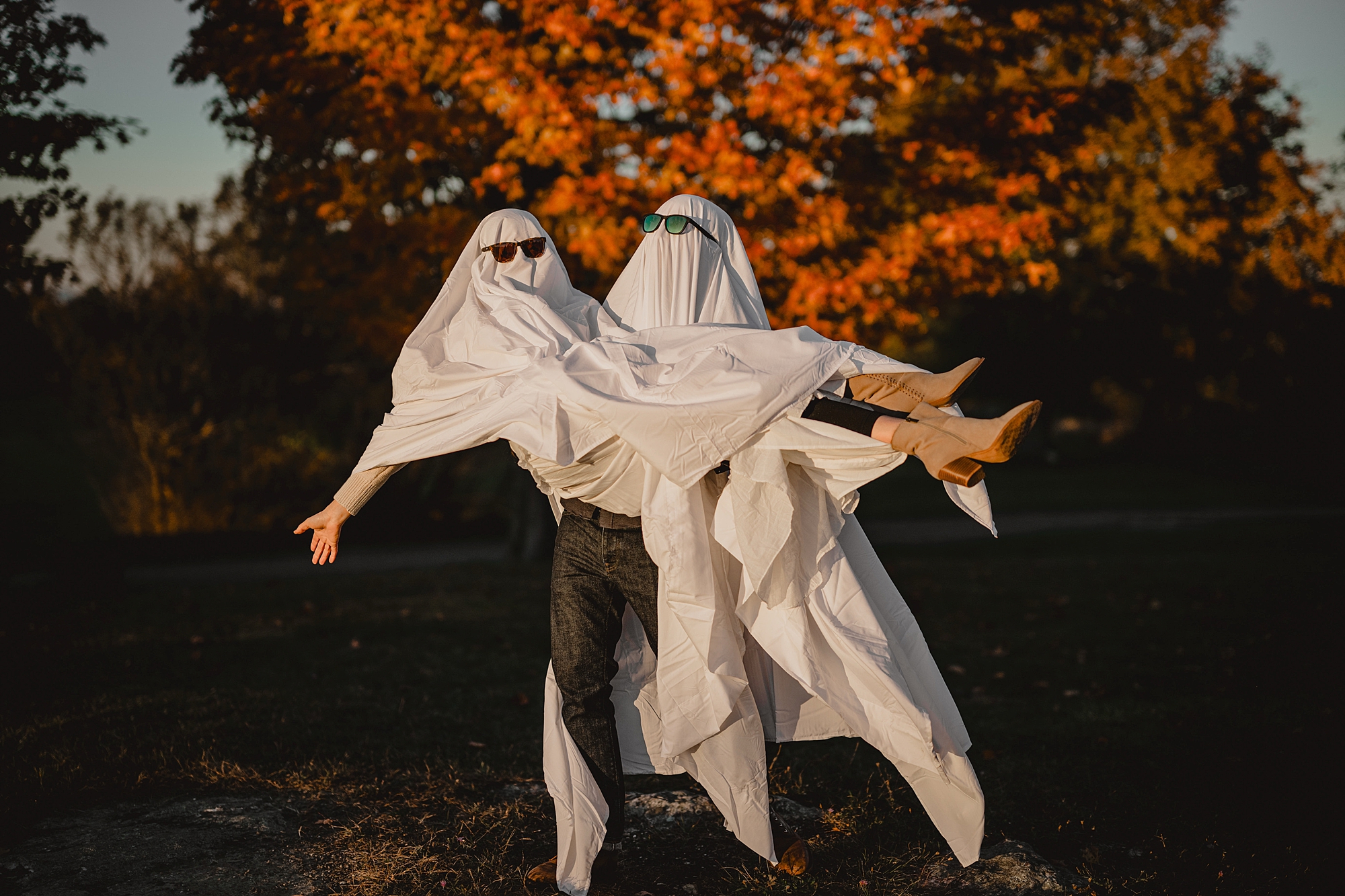 man lifts up woman while both are wearing ghost costumes Hudson Valley NY engagement session