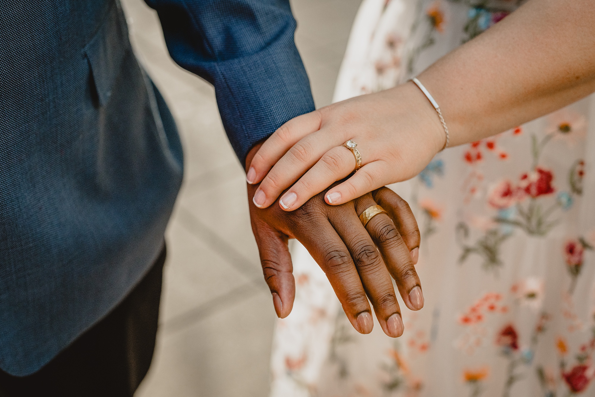 bride holds groom's arm showing off wedding band