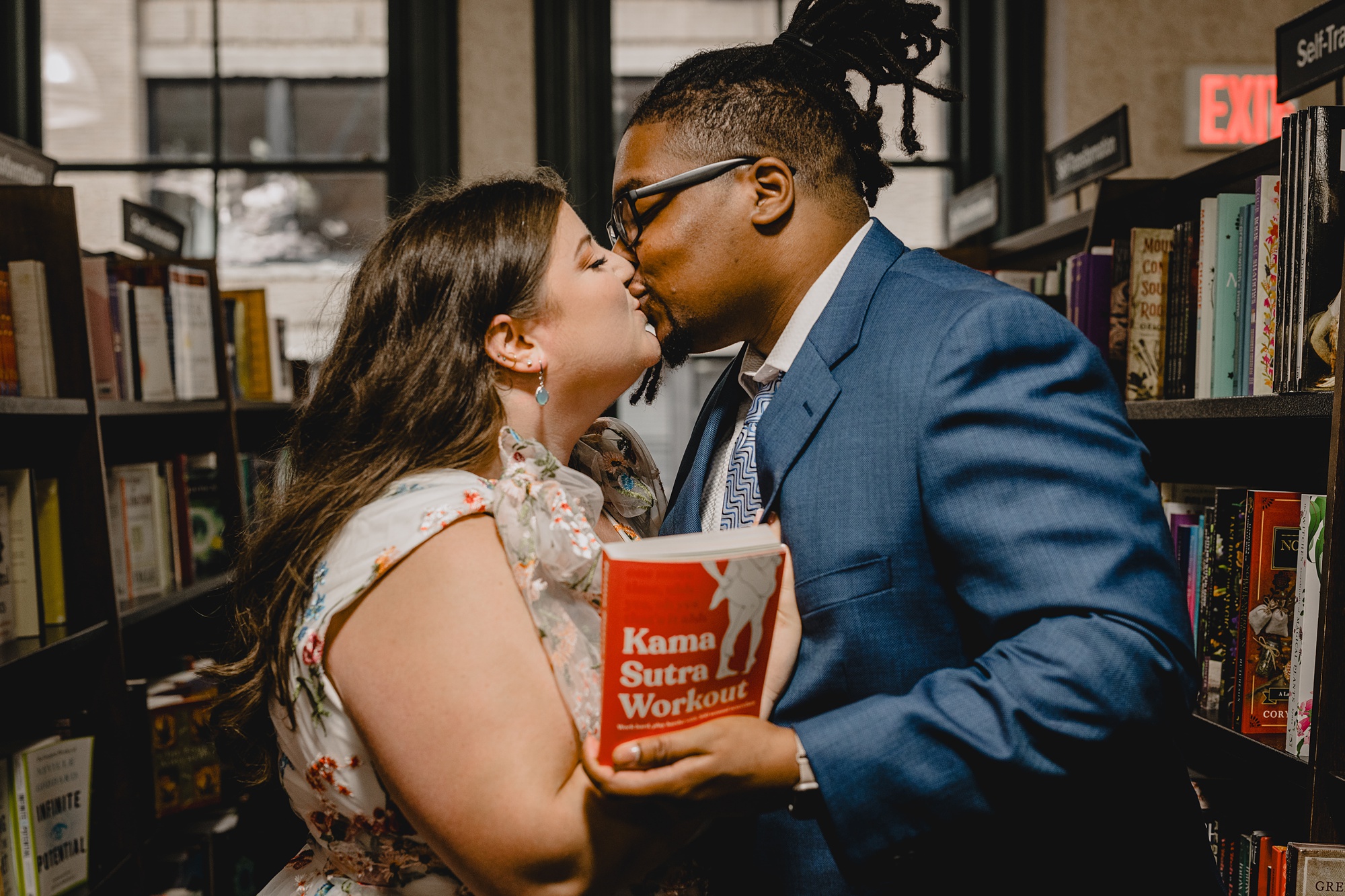 couple kisses behind red cover of Karma Sutra inside Barnes & Noble in NYC