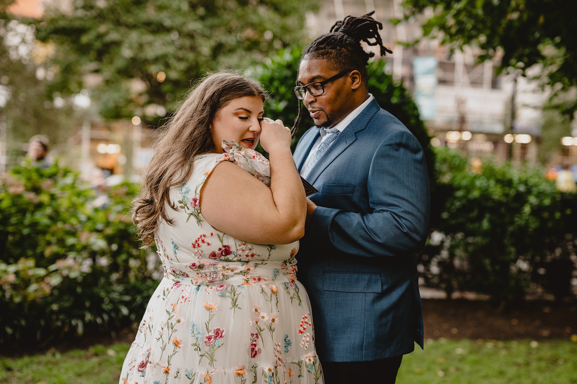 woman wipes away tears inside NYC park