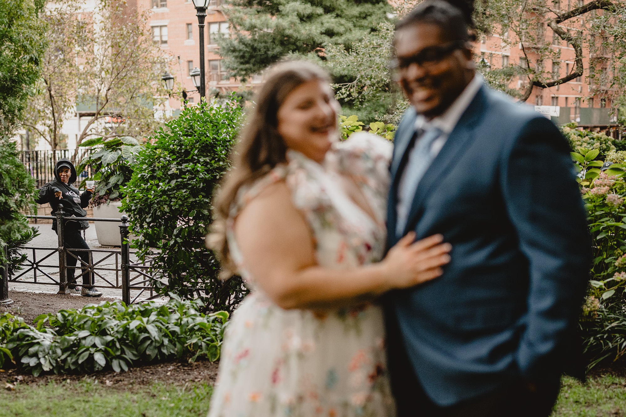 woman looks at couple posing in NYC park