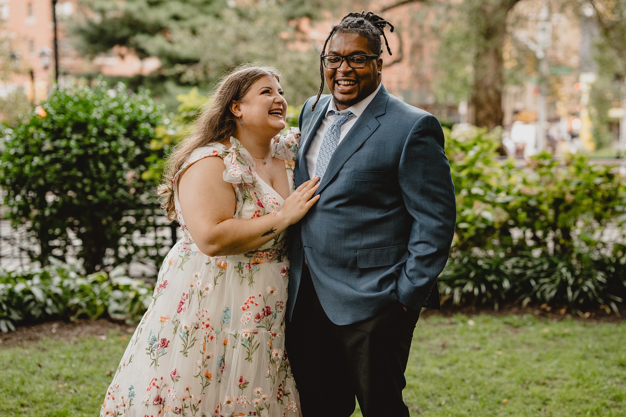 man and woman laugh together on wedding day in NYC park