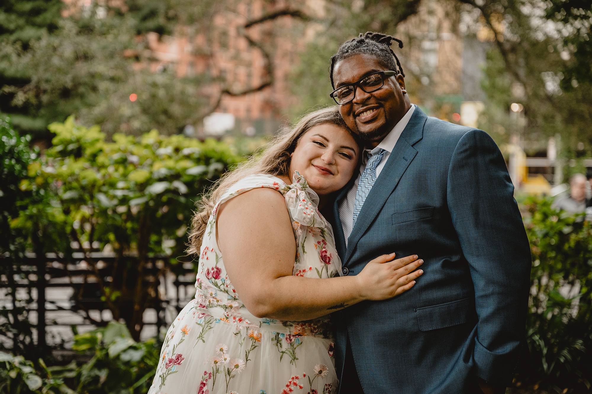 woman lays head on groom's chest inside NYC park