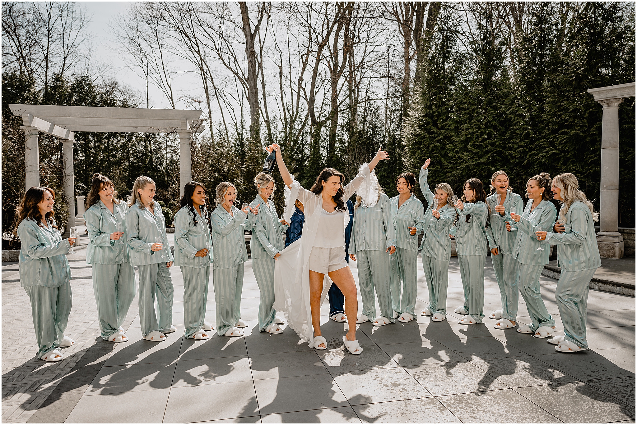 bride cheers with champagne bottle on patio at the Estate at Florentine Gardens