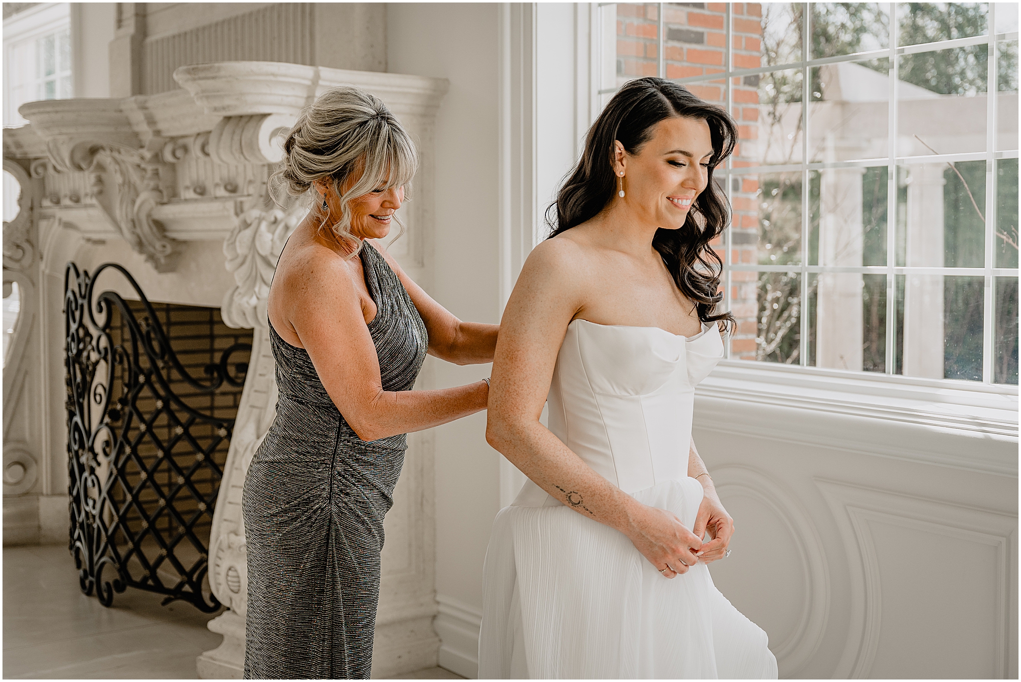 mother helps bride into wedding gown in suite at the Estate at Florentine Gardens
