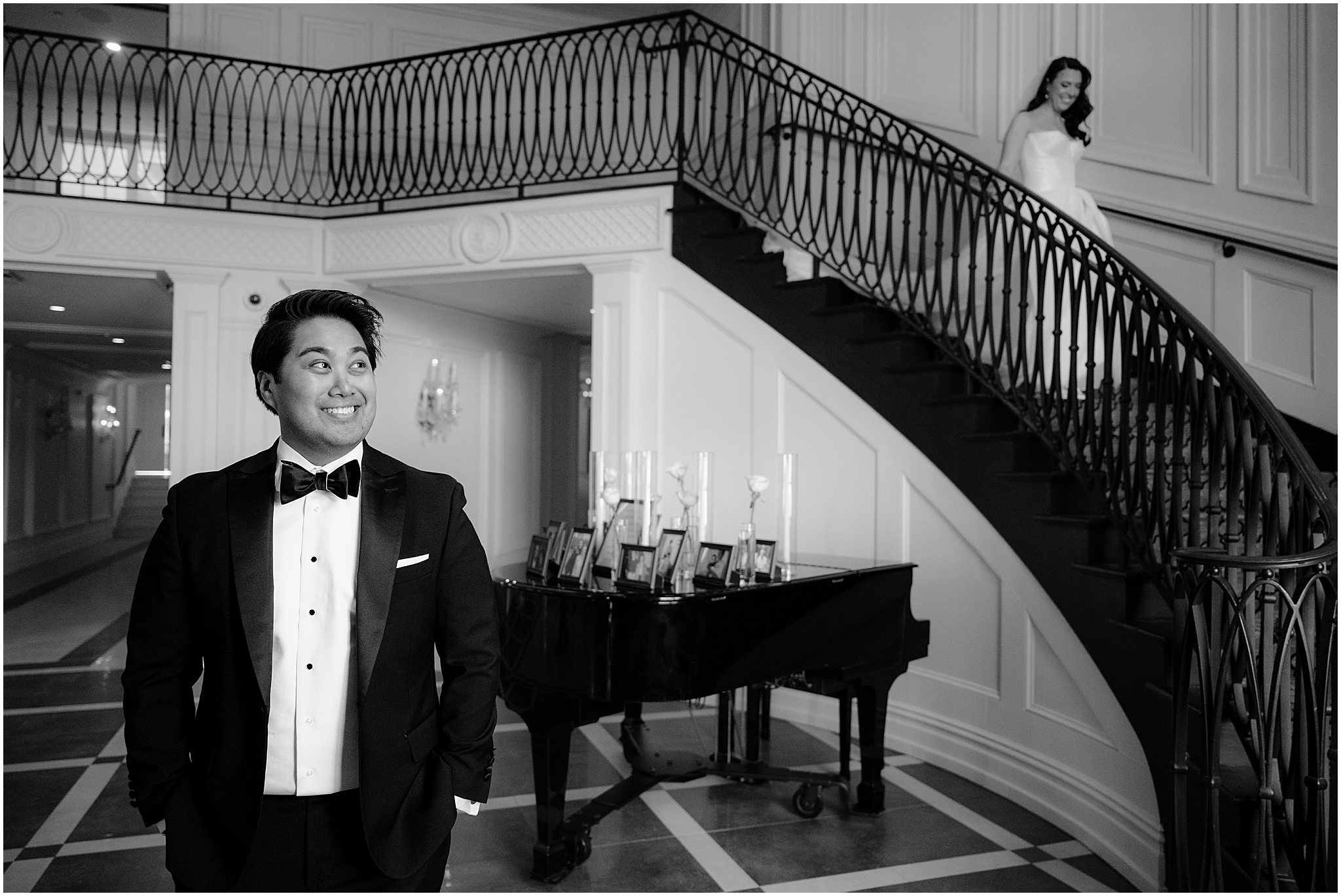 bride walks down staircase inside the Estate at Florentine Gardens to meet grinning groom
