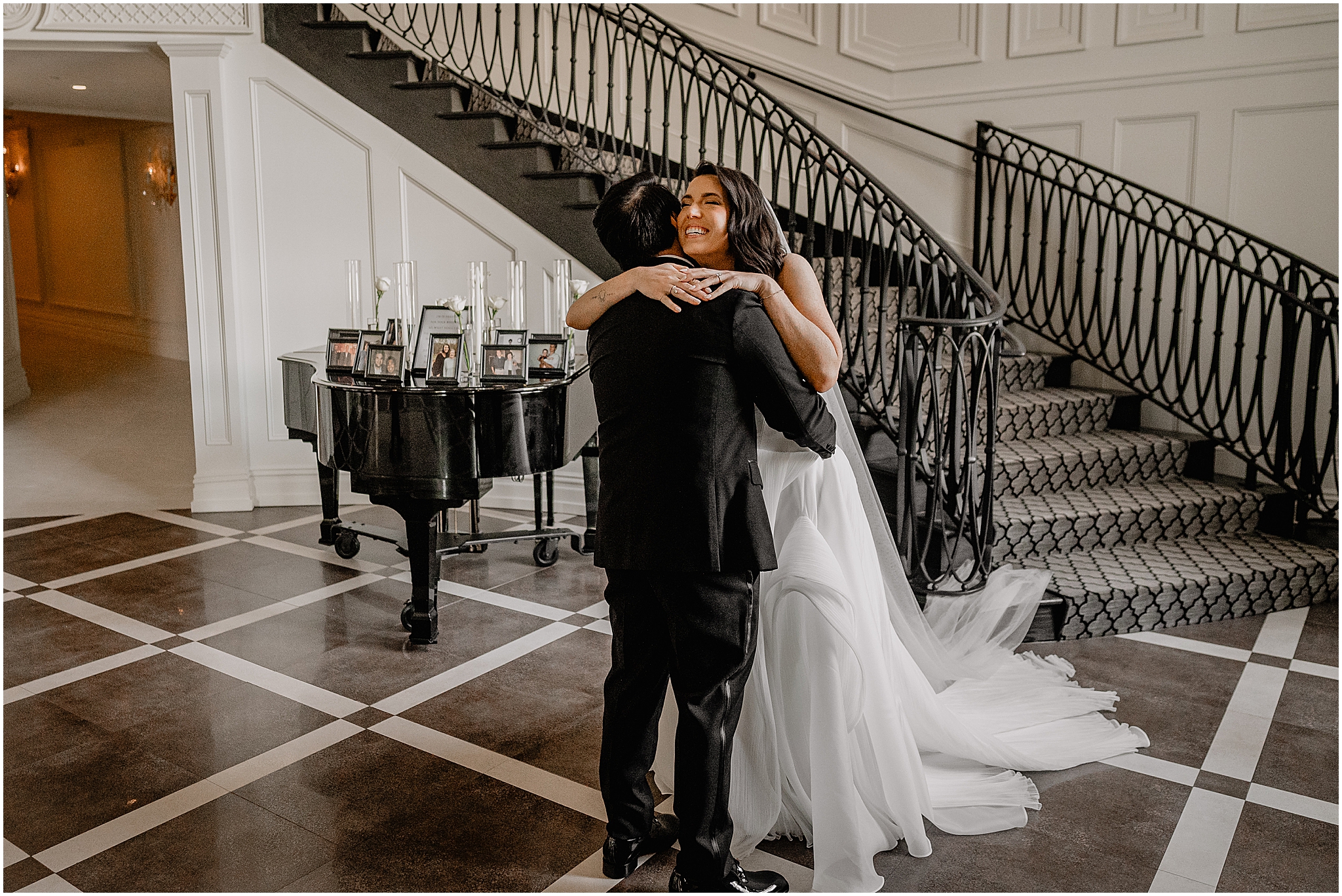 bride and groom grin inside lobby of the Estate at Florentine Gardens hugging