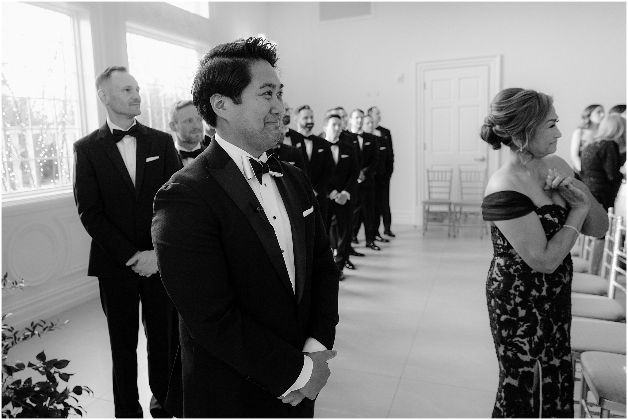 groom grins watching bride walk down aisle during wedding ceremony 