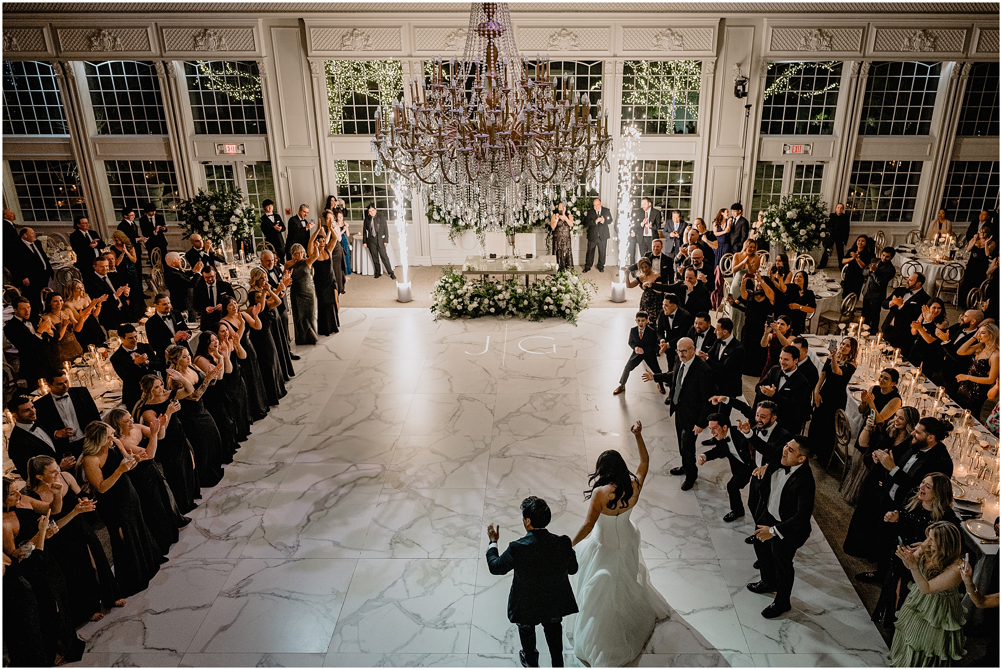 newlyweds cheer and wave walking into wedding reception at the Estate at Florentine Gardens