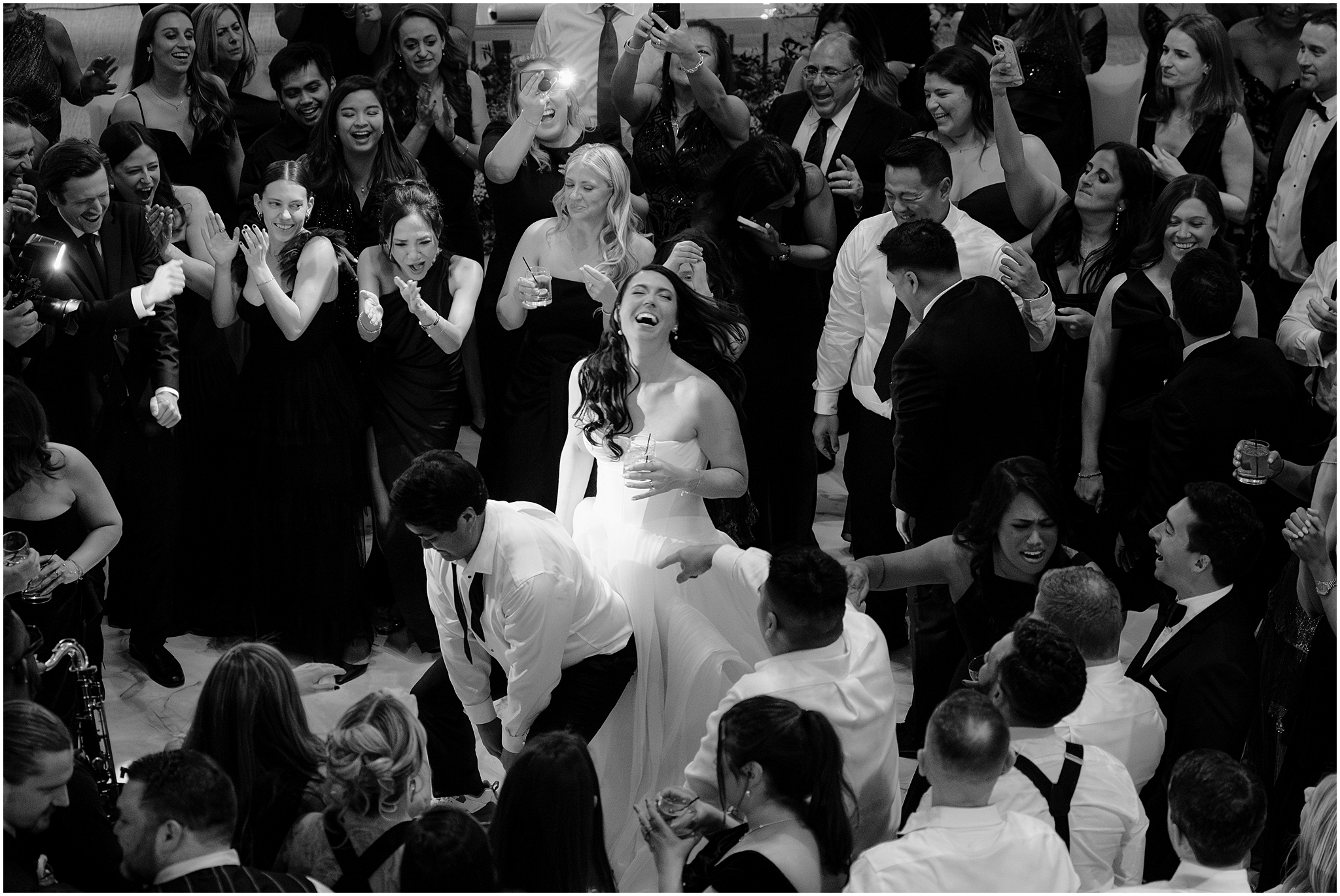 man dances against bride's wedding dress while she laughs during River Vale NJ wedding reception