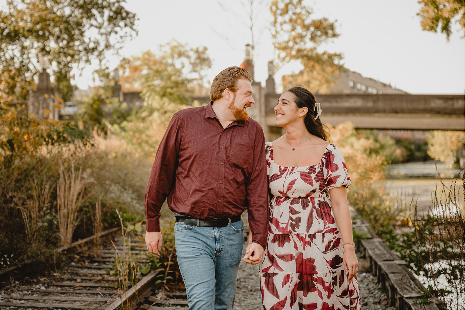 engaged couple walks on railroad line in Philly PA neighborhood