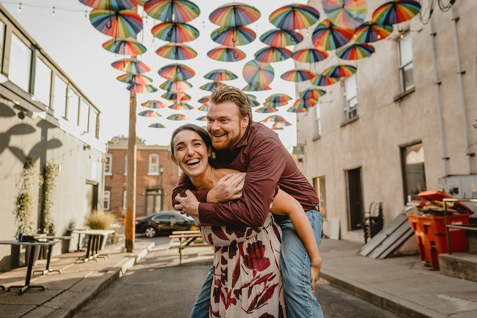 woman gives man piggy back ride during Manayunk engagement session in Philly PA