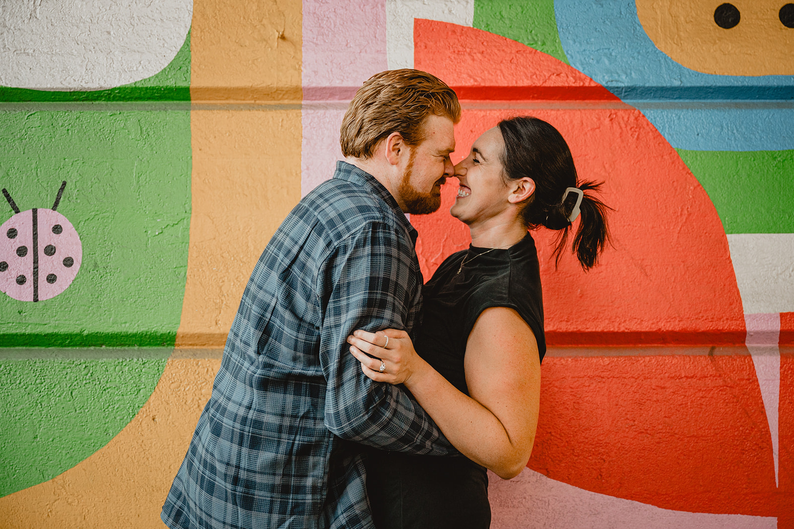 engaged couple lean together nuzzling noses during Manayunk engagement session