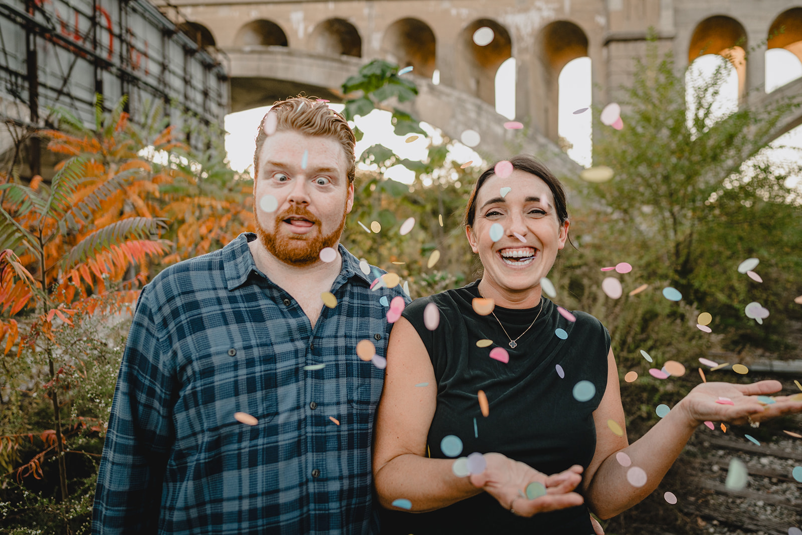 couple makes funny faces while tossing confetti 