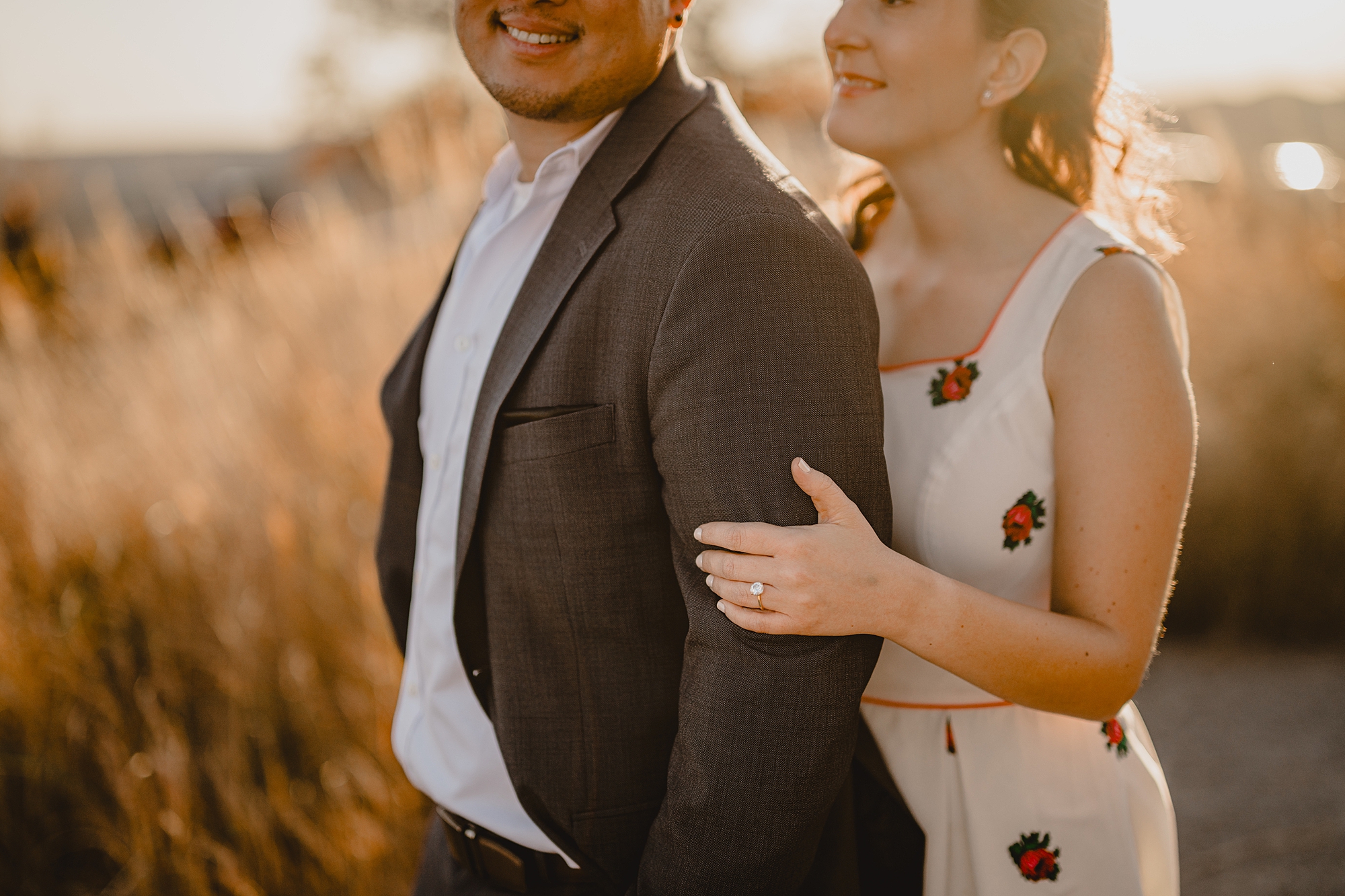 woman in white dress holds man's arm during fall engagement session on Bear Mountain