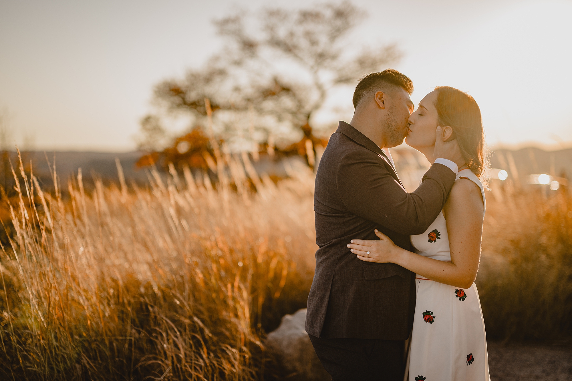 engaged couple kisses at sunset during fall engagement session on Bear Mountain