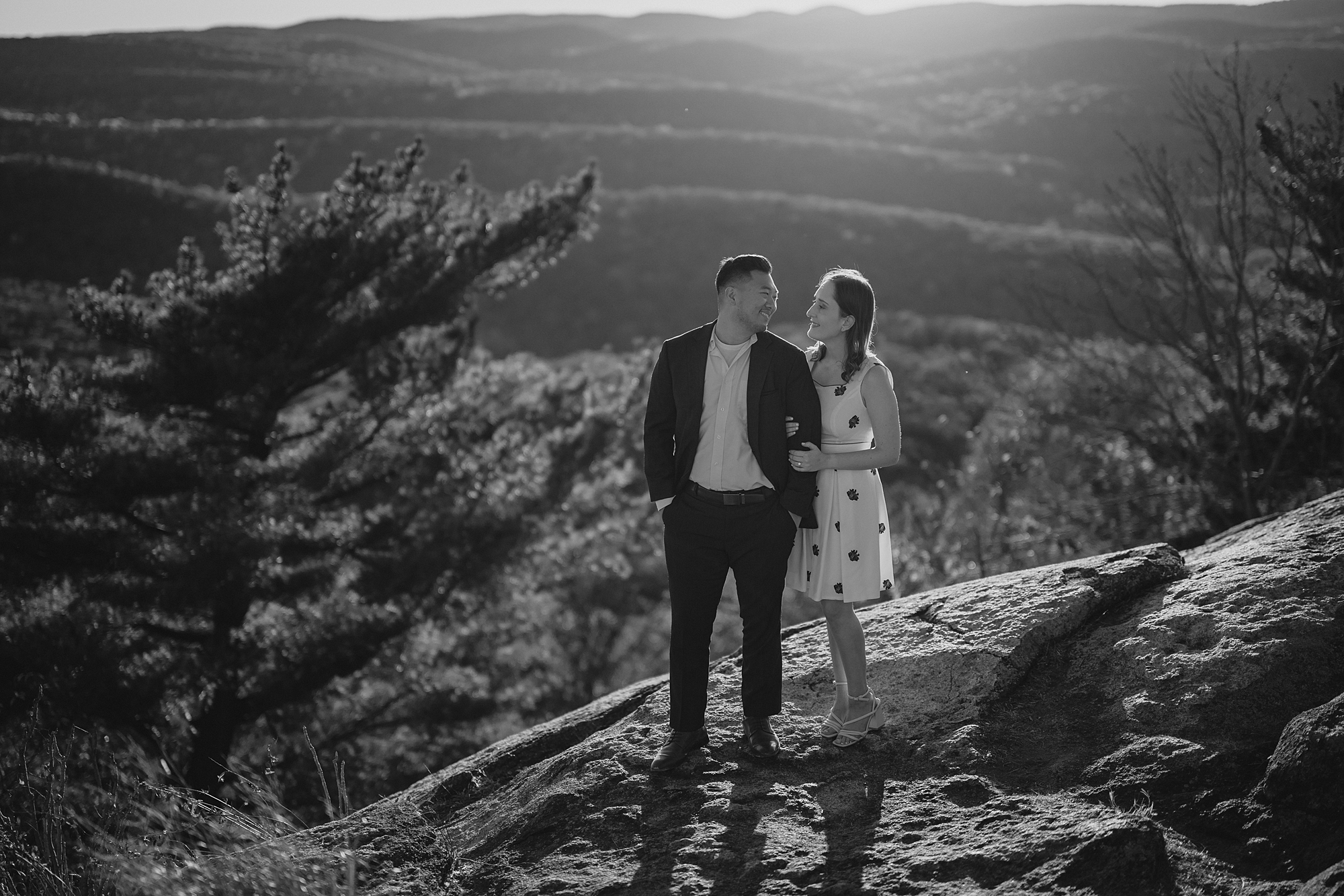 man and woman stand together on mountain top 