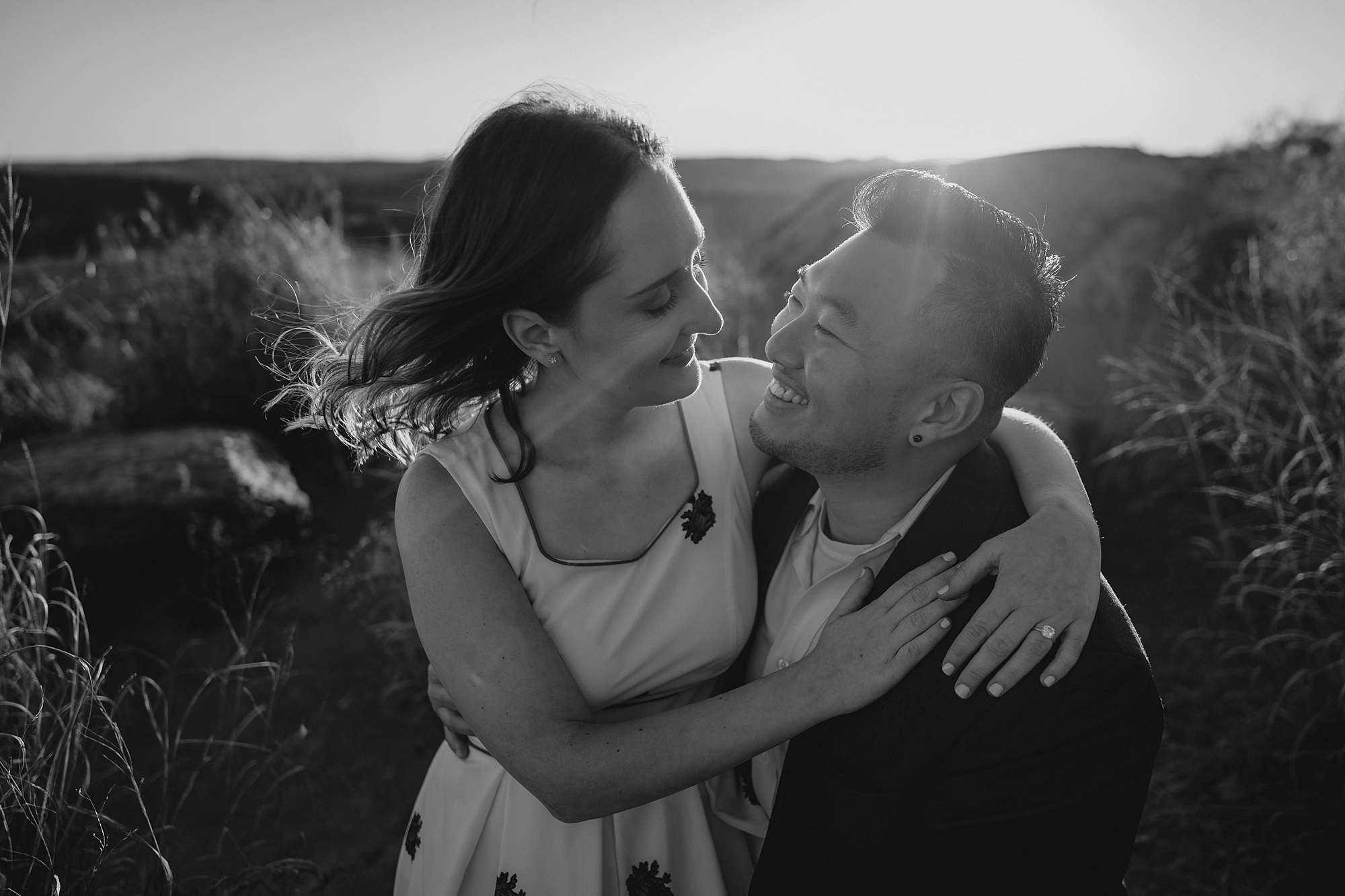 woman sits on man's lap during fall engagement session on Bear Mountain