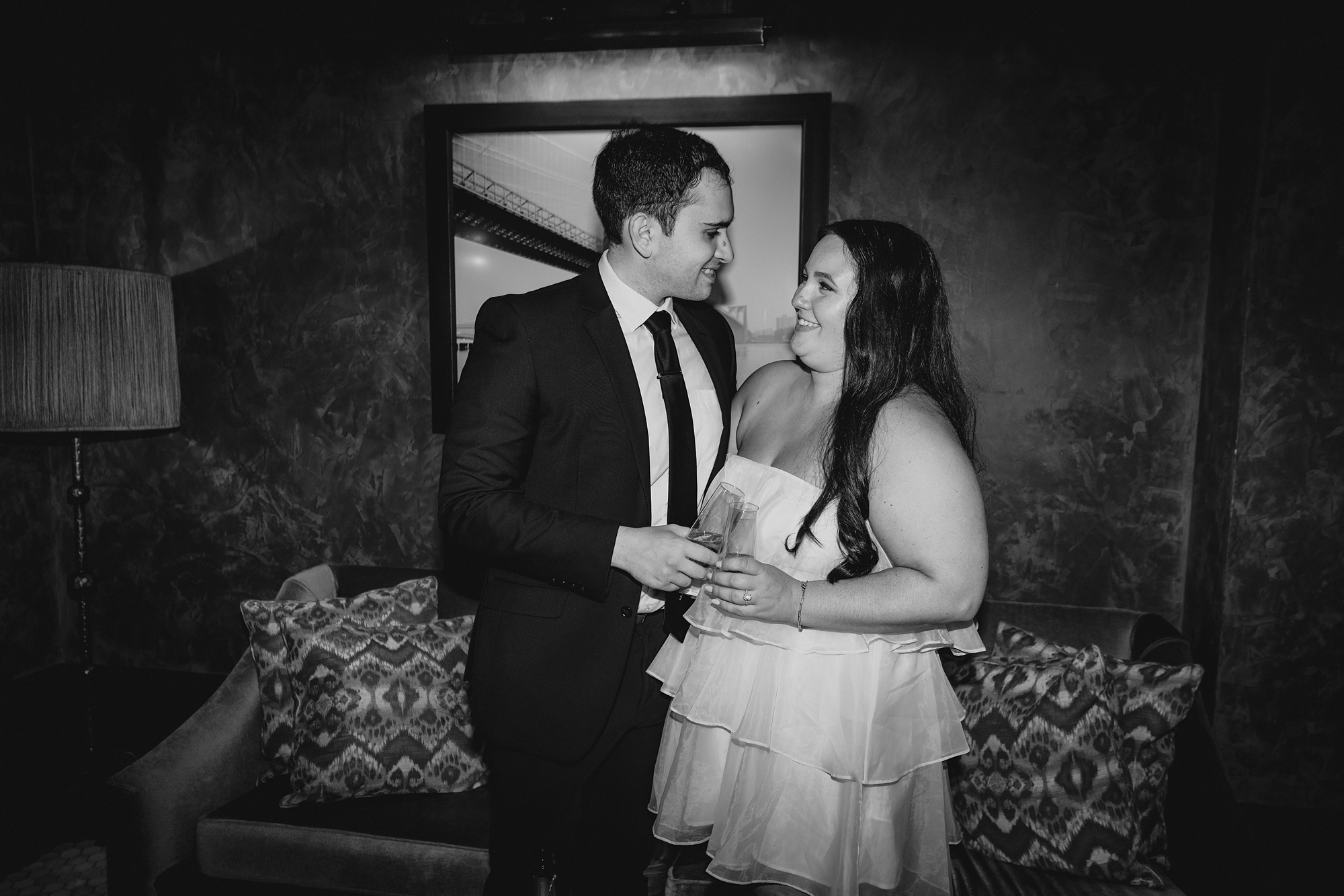 engaged couple toasts champagne standing inside the Beekman Hotel