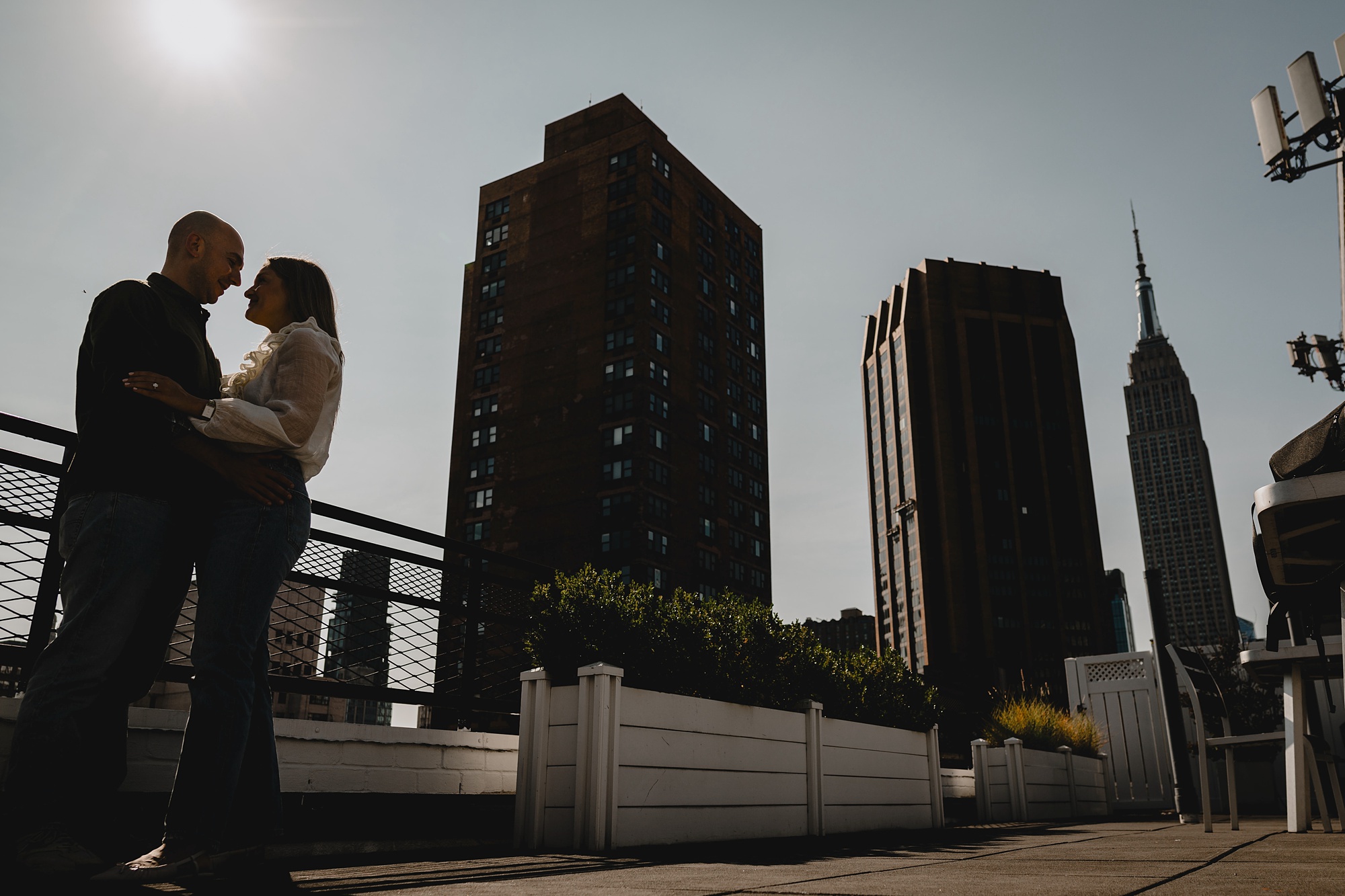 engaged couple hugs in front of NYC skyline during Murray Hill engagement session