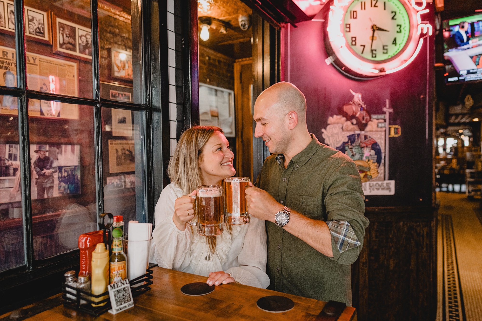 man and woman toast beers inside Jackson Hole