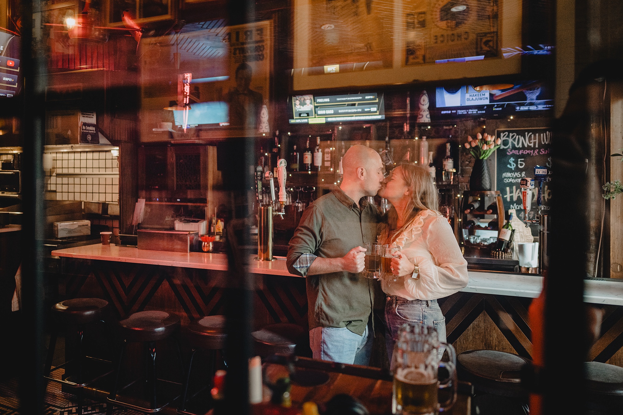 man and woman kiss in front of bar inside Jackson Hole