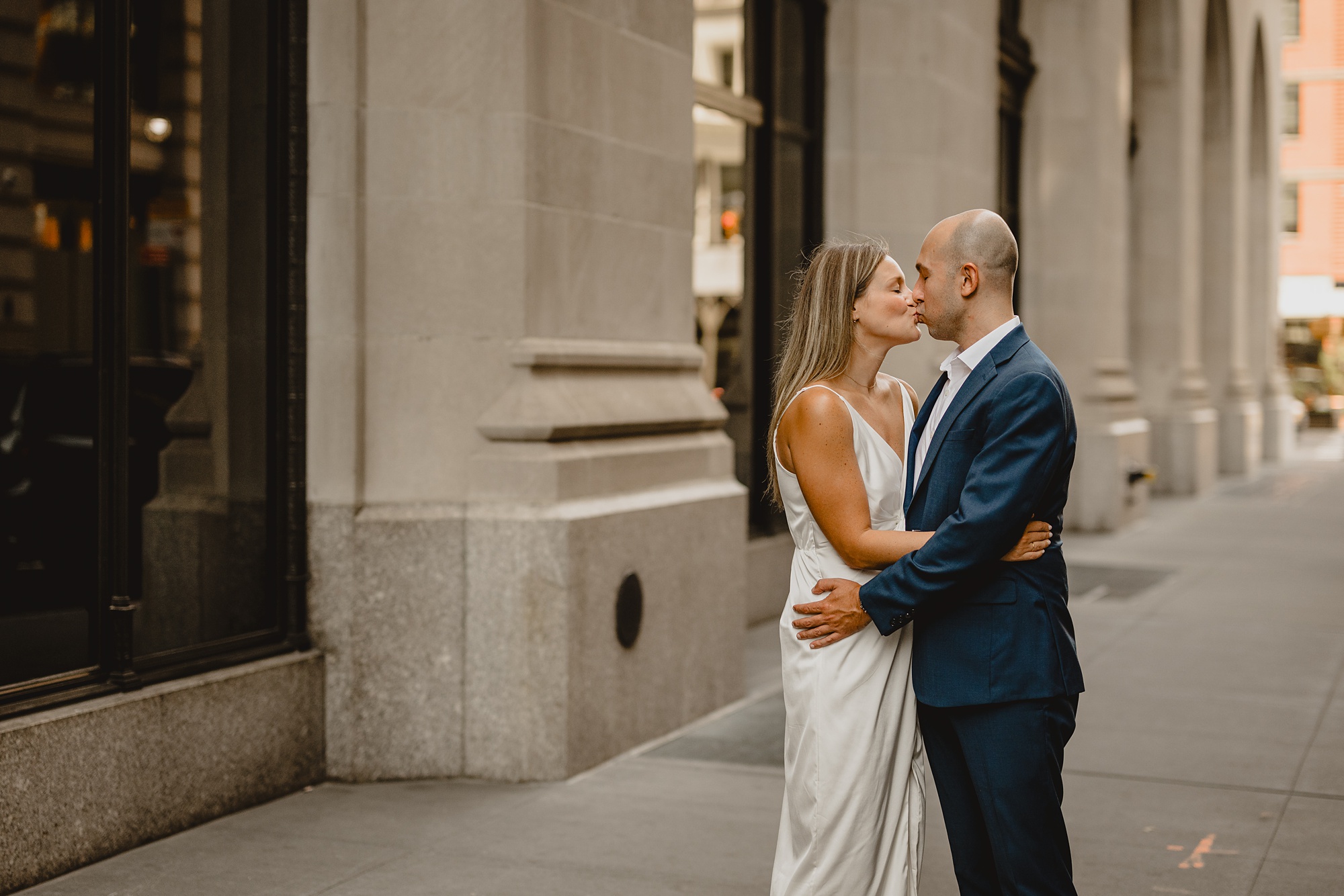 man and woman kiss on street in NYC during engagement photos