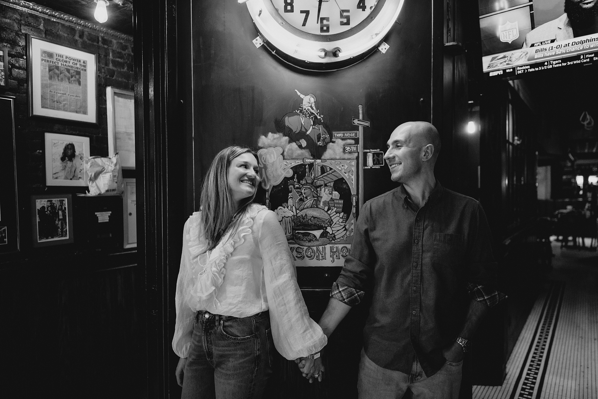 man and woman hold hands under neon signs in Jackson Hole