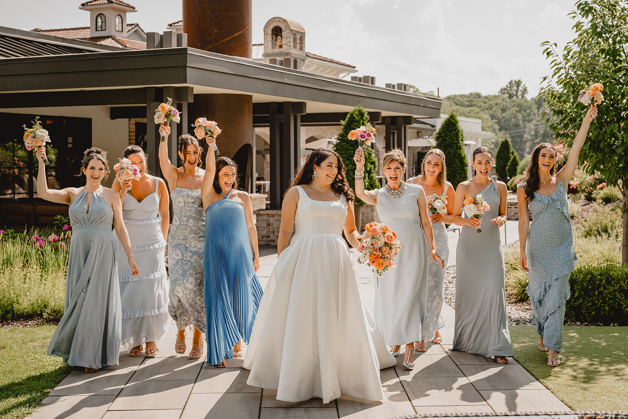 bride walks with bridesmaids on grounds at the Refinery at Perona Farms
