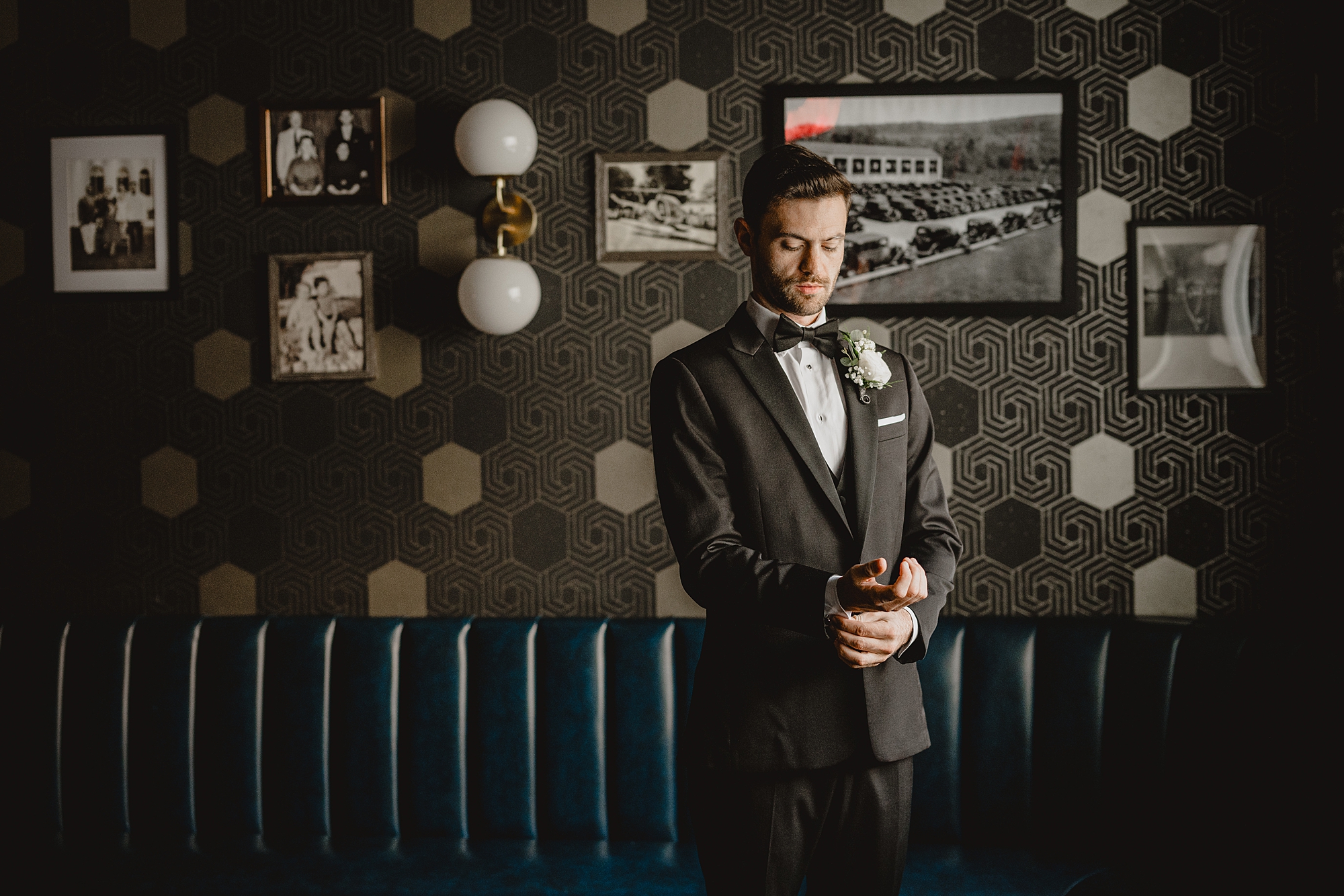 groom adjusts cufflinks during portraits inside the Refinery at Perona Farms