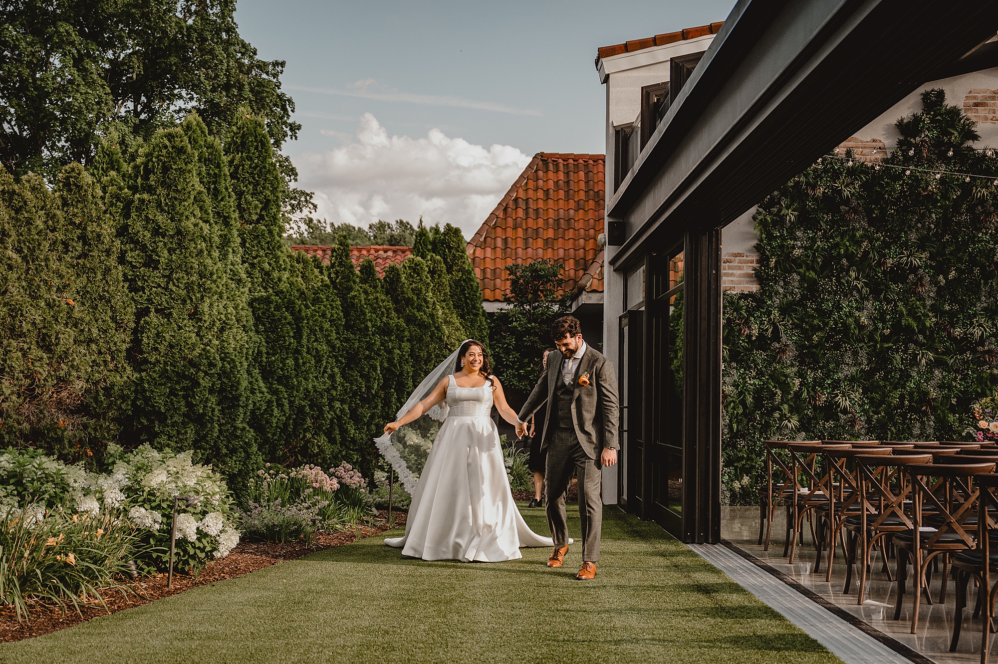 bride and groom hold hands walking down path at the Reserve at Perona Farms