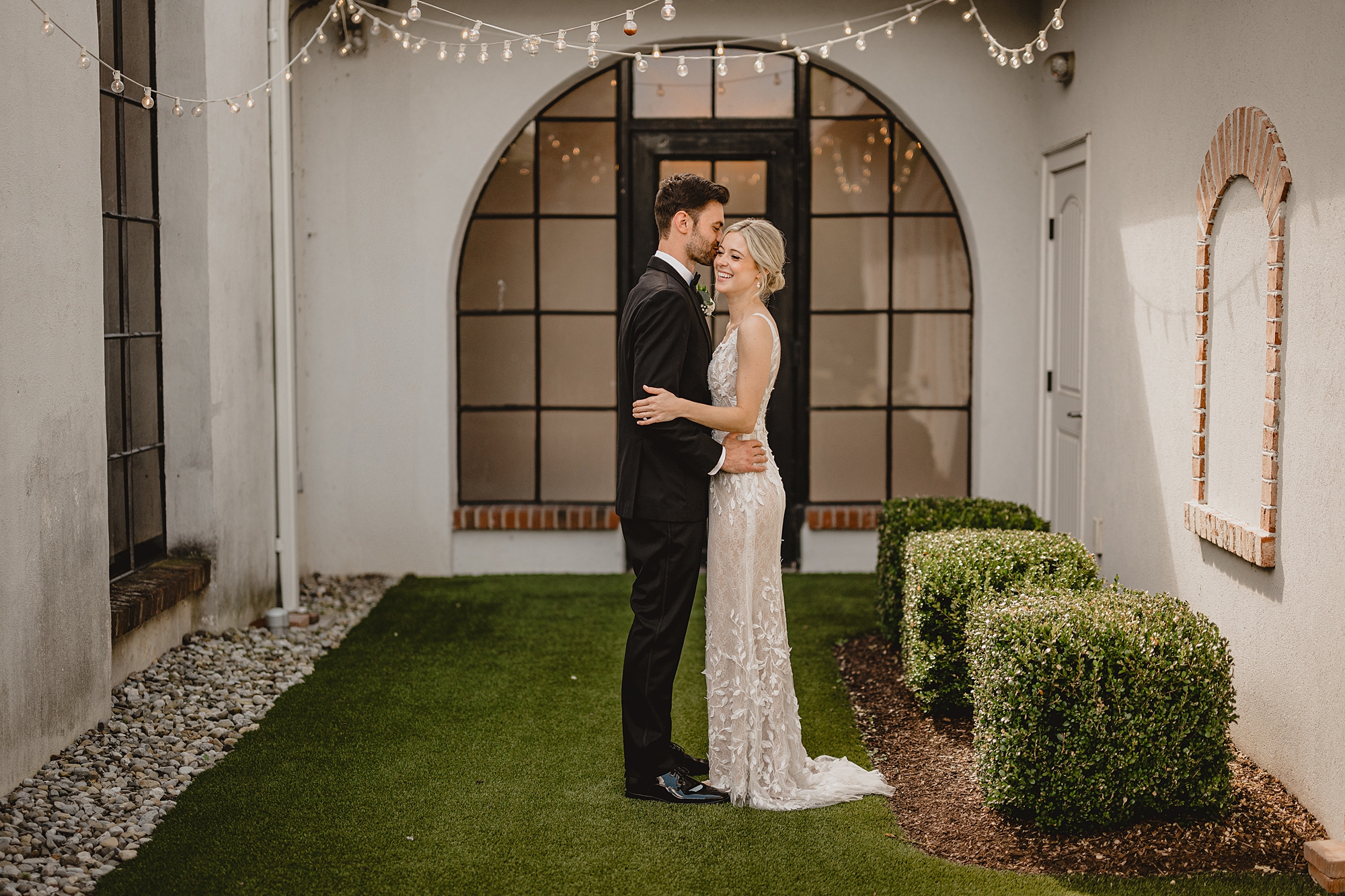 bride and groom stand together in hallway at food at the Refinery at Perona Farms