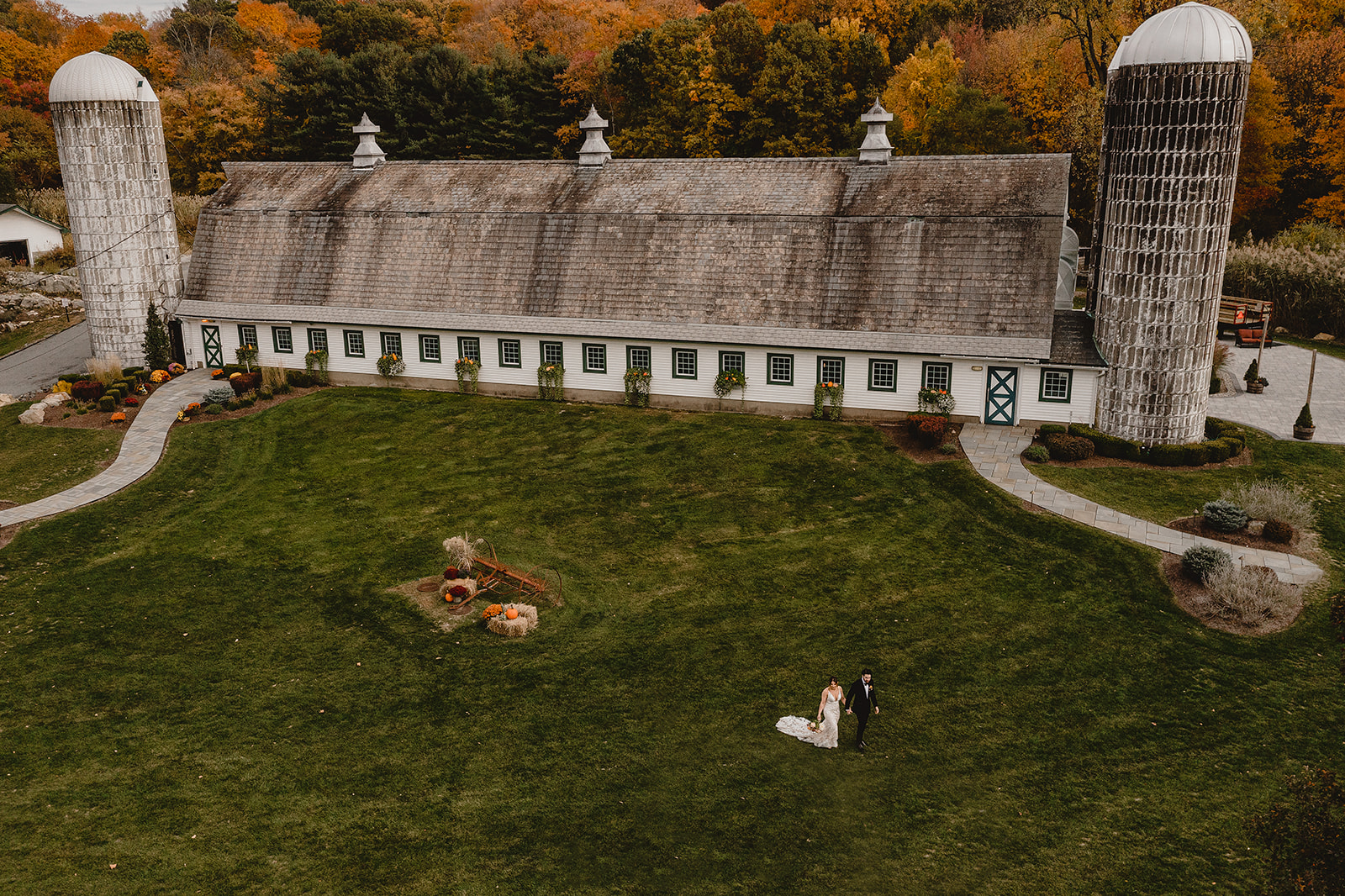 couple walks on lawn by the the Barn at Perona Farms