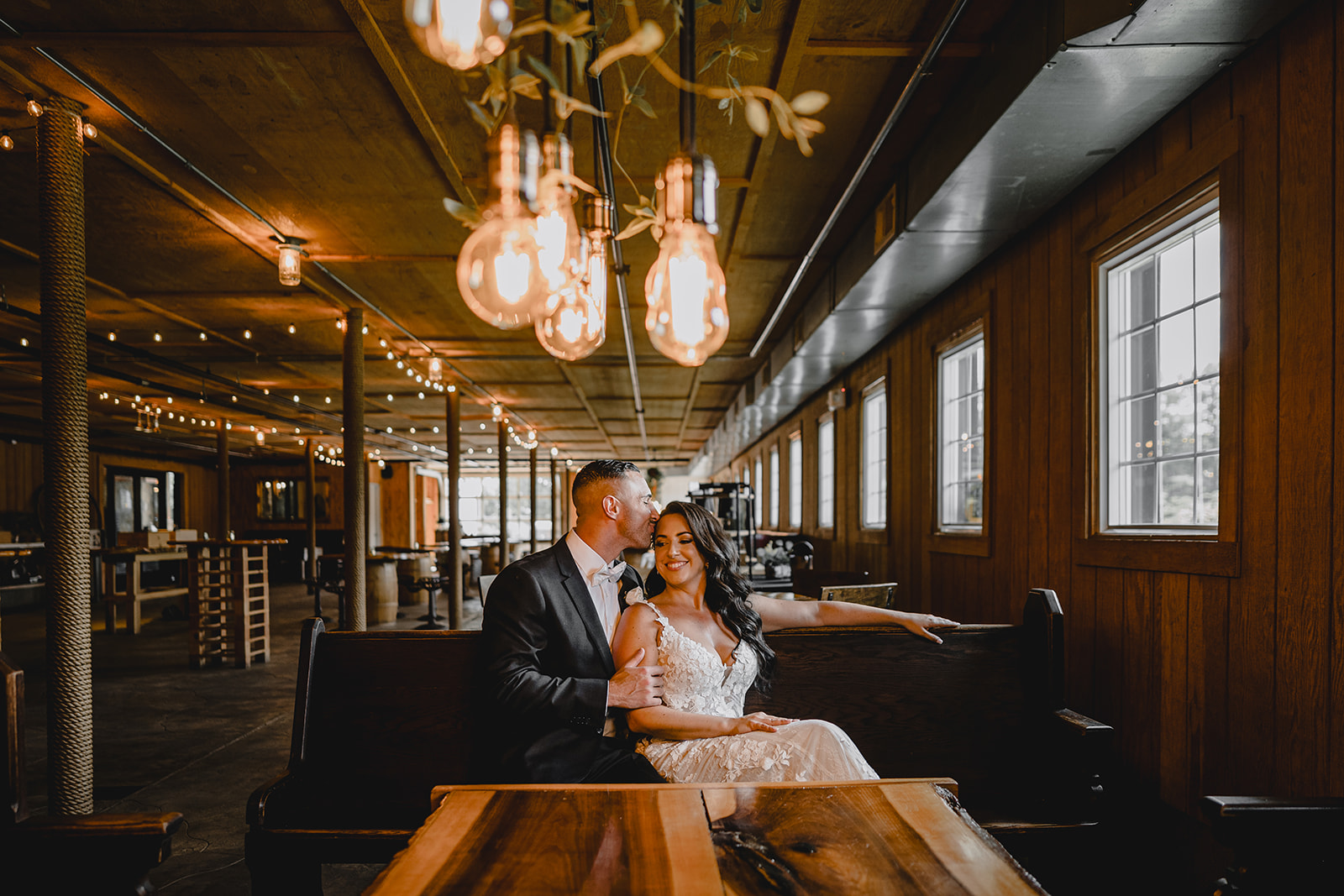couple hugs sitting inside the Barn at Perona Farms