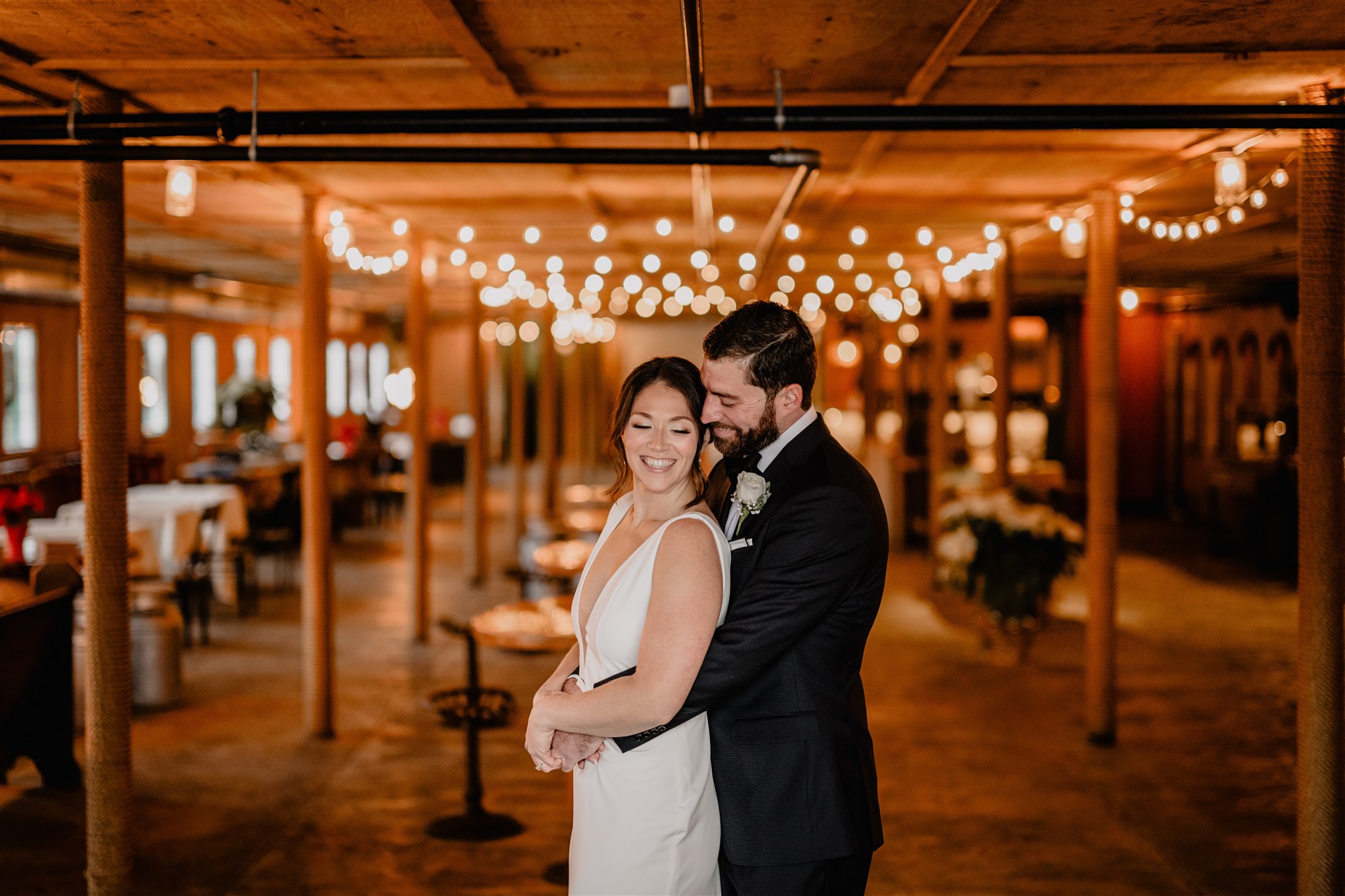 man hugs bride inside the Barn at Perona Farms