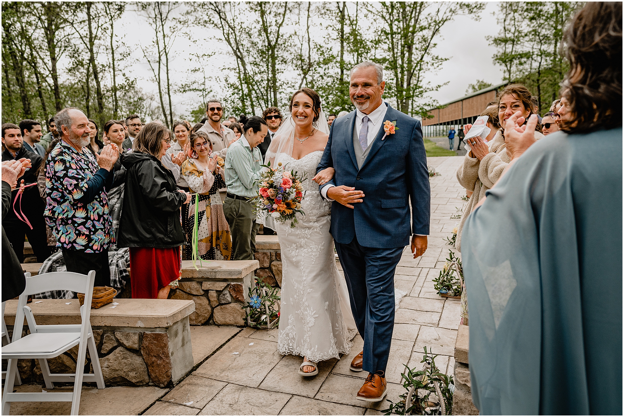 bride walking down the aisle at their colorful wedding at Camp Lindenmere
