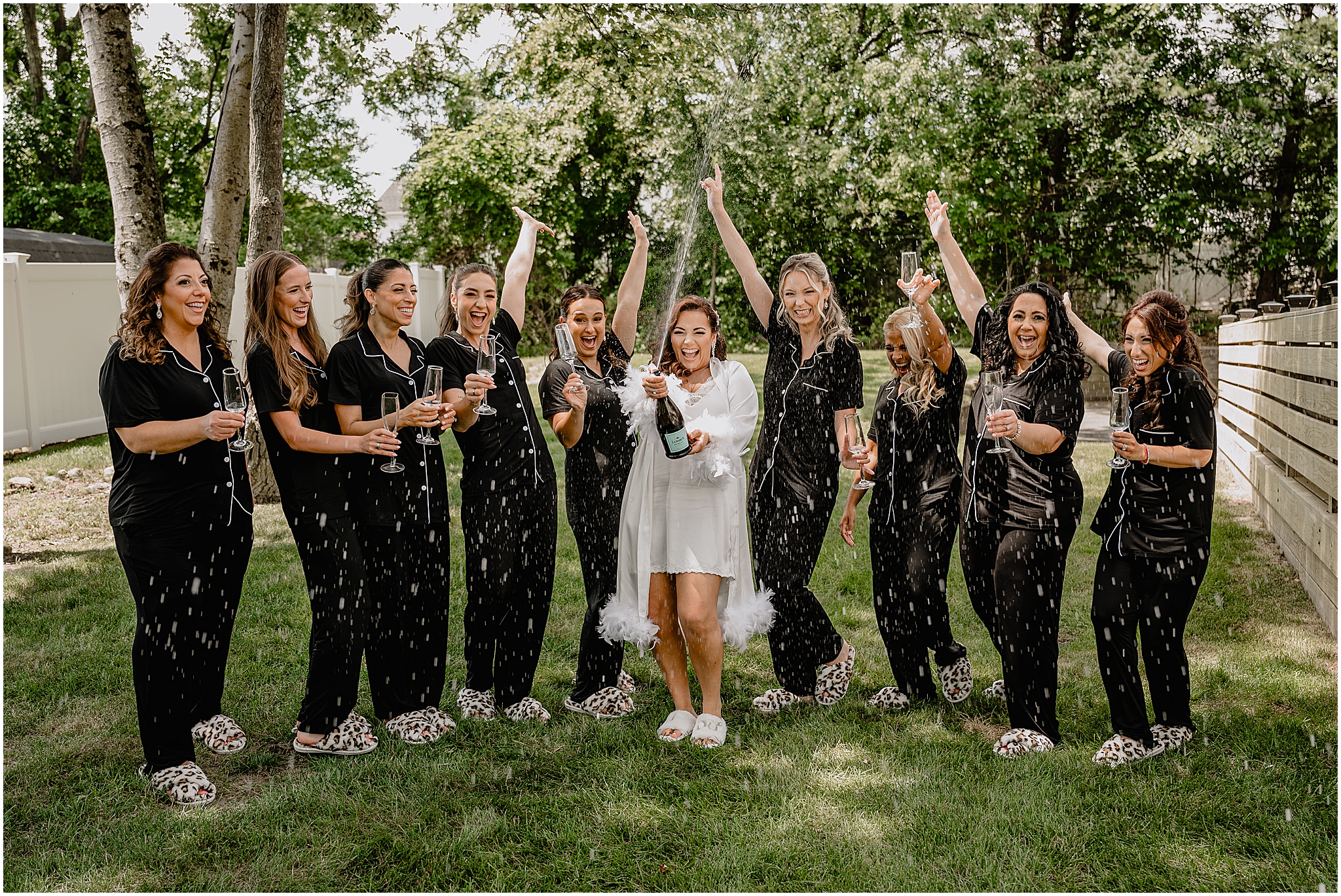 Bride opening a bottle of champagne with her bridesmaids before her Summer Park Chateau Wedding, capturing a joyful and candid moment.