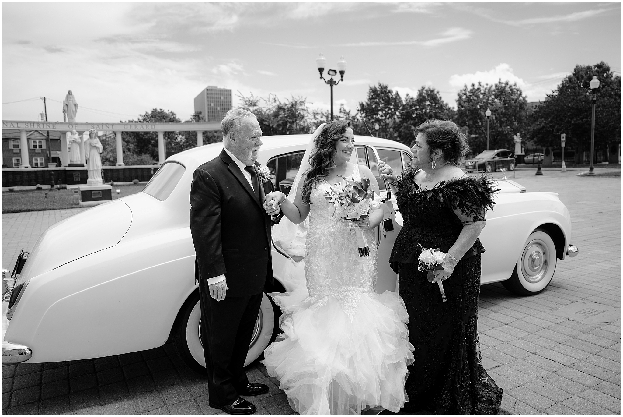 Bride with her parents outside the church before her Summer Park Chateau Wedding, capturing a heartfelt family moment.