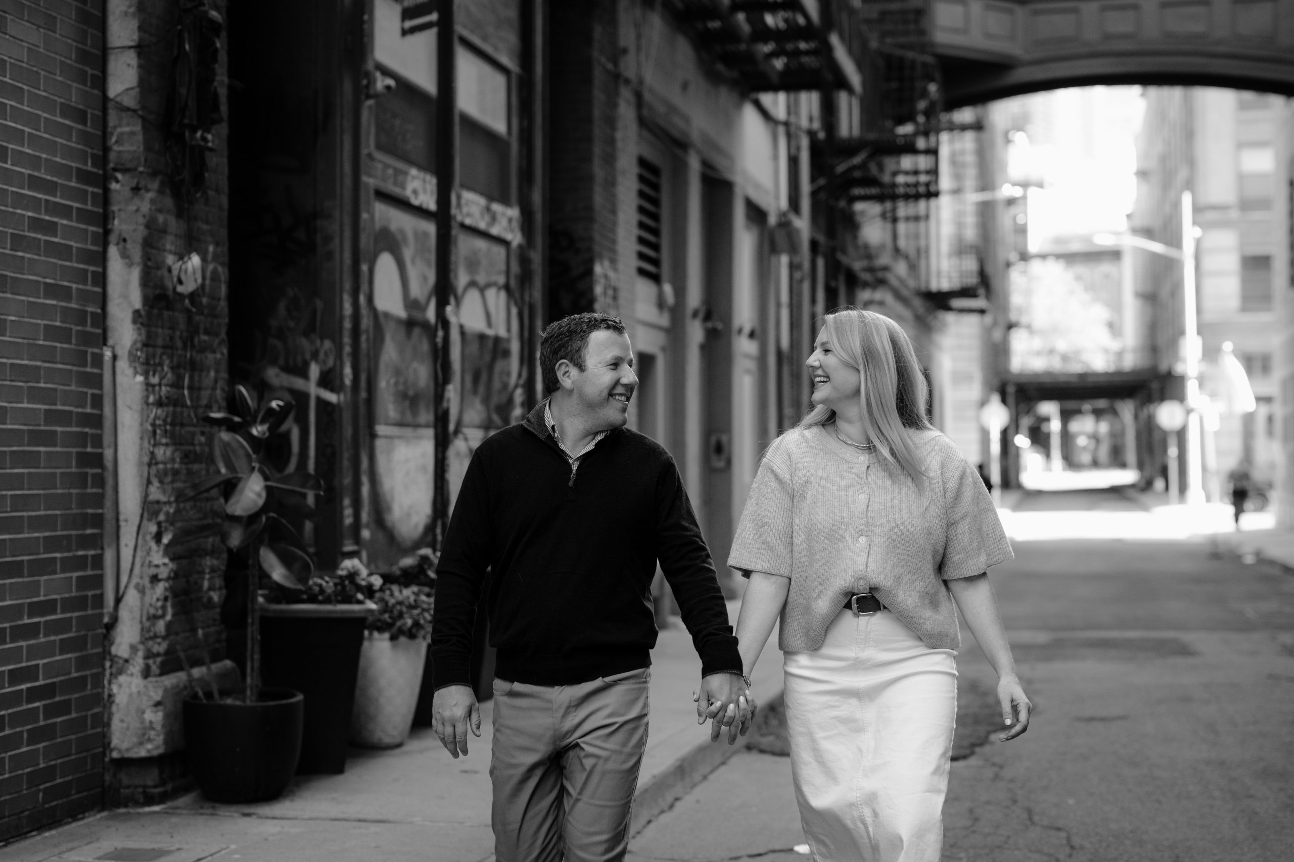 Black and white photo of the couple walking during their Tribeca NYC engagement session.