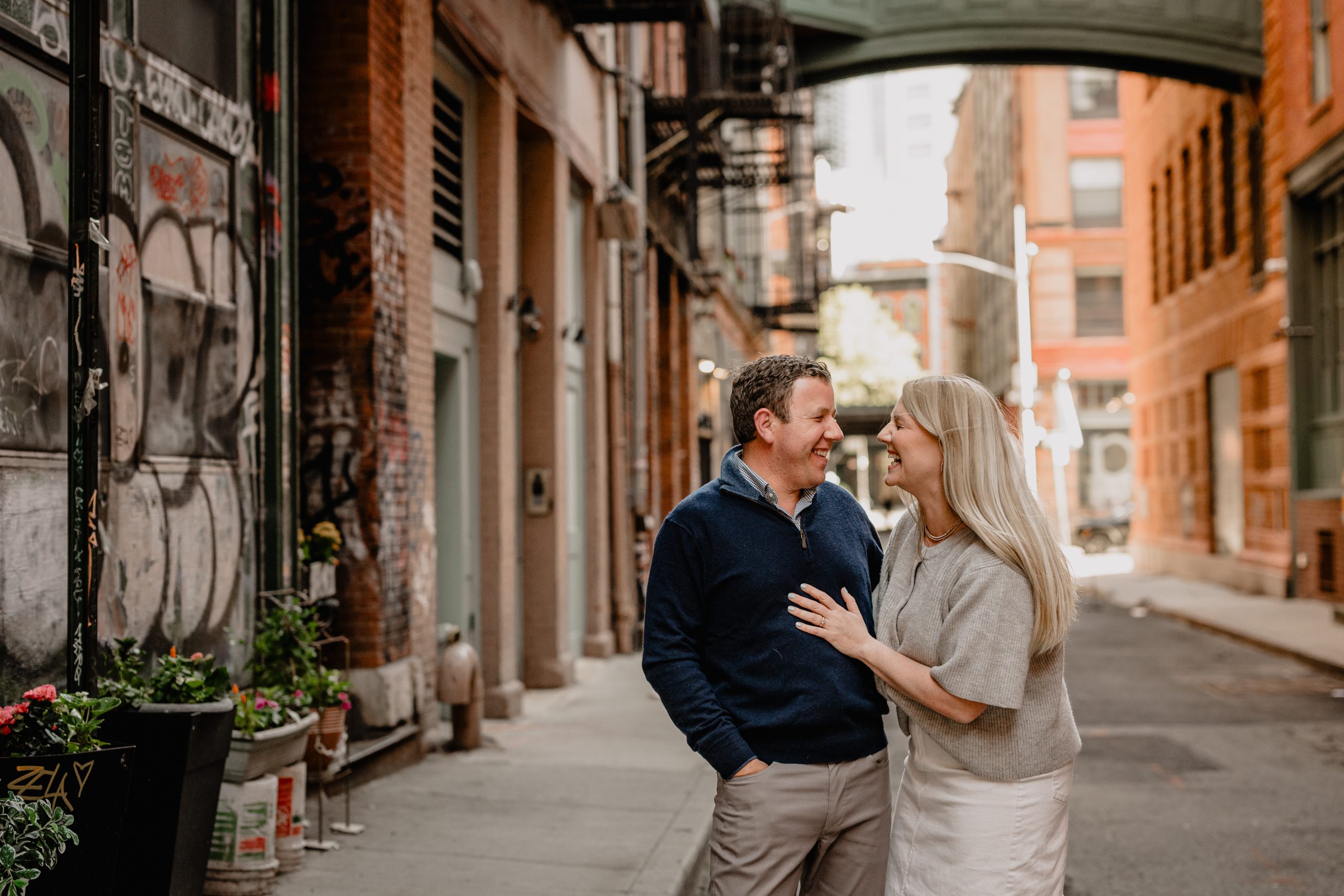 Couple laughing and walking during their Tribeca NYC engagement session.