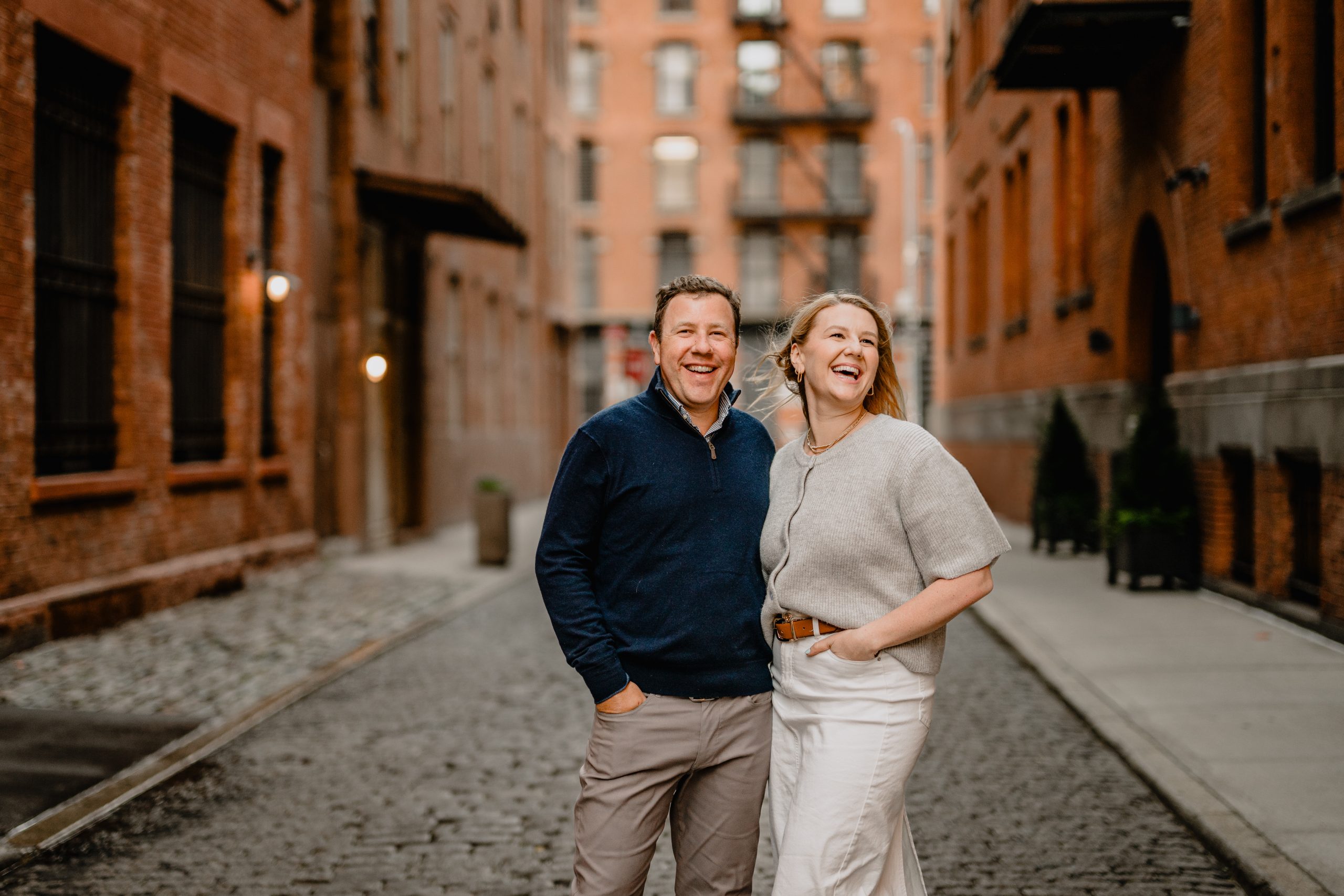 Couple laughing and walking during their Tribeca NYC engagement session.