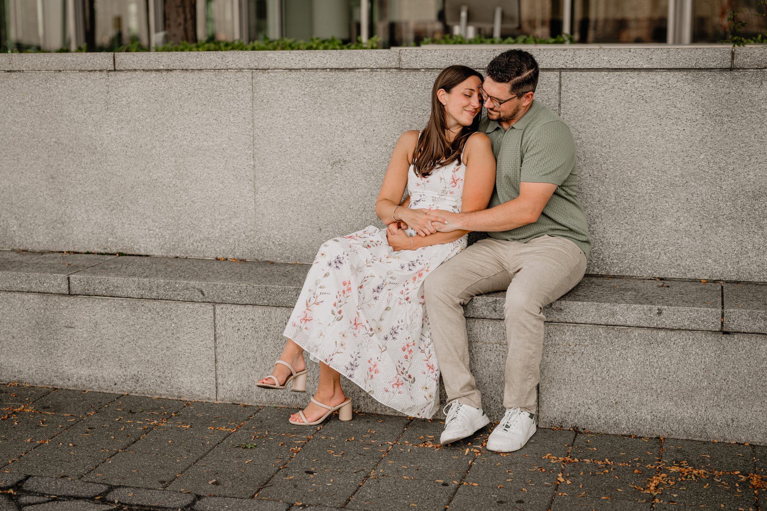 Couple sitting and hugging during their Jersey City Engagement at Paulus Hook.