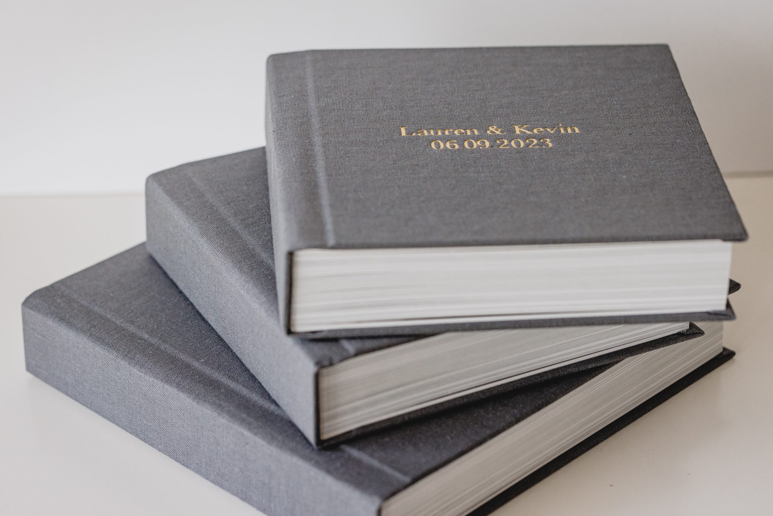 Stack of elegant wedding albums with custom covers, designed by a New Jersey wedding photographer.