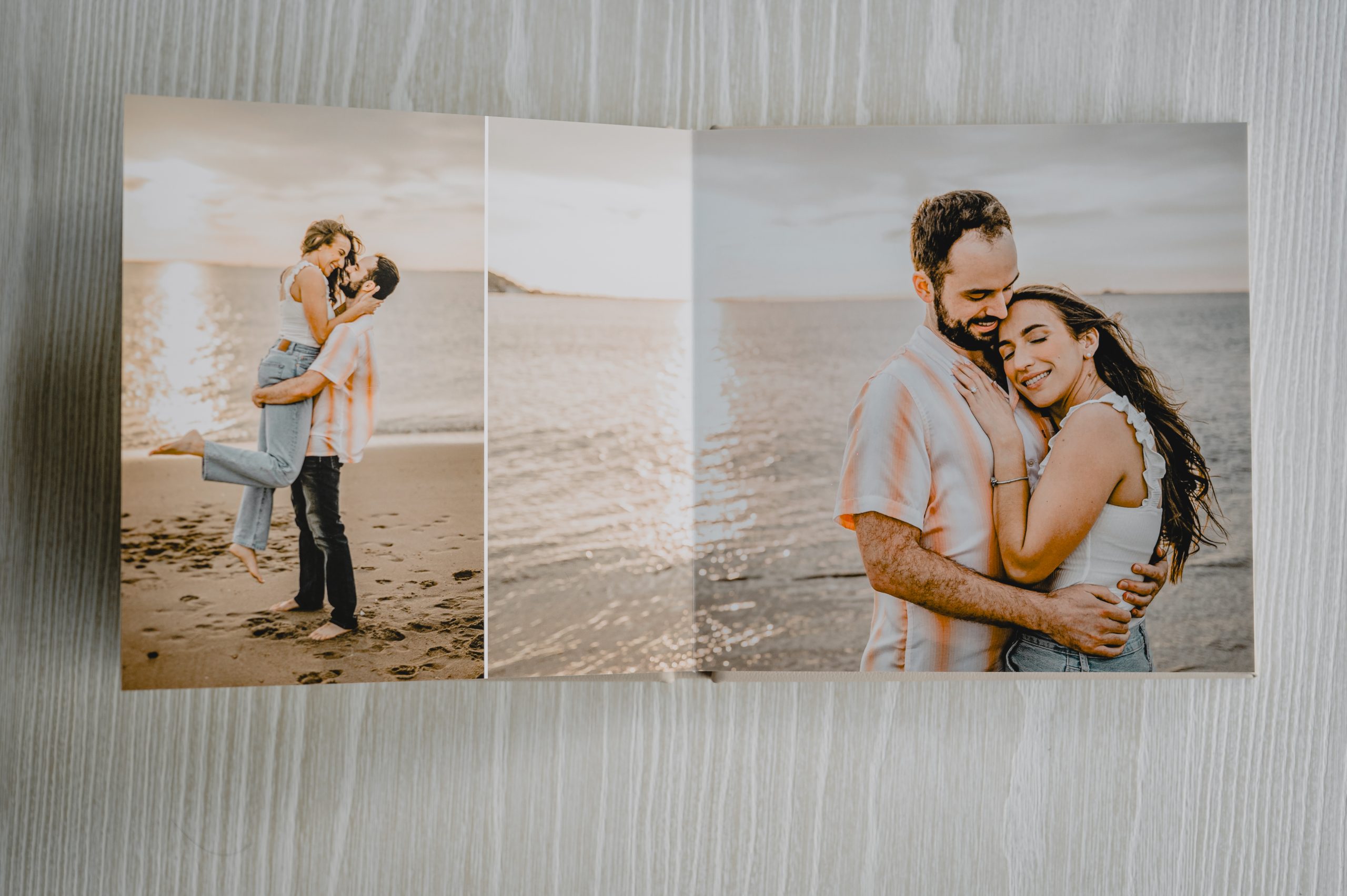 Open wedding album with romantic beach engagement photos, created by a New Jersey wedding photographer.