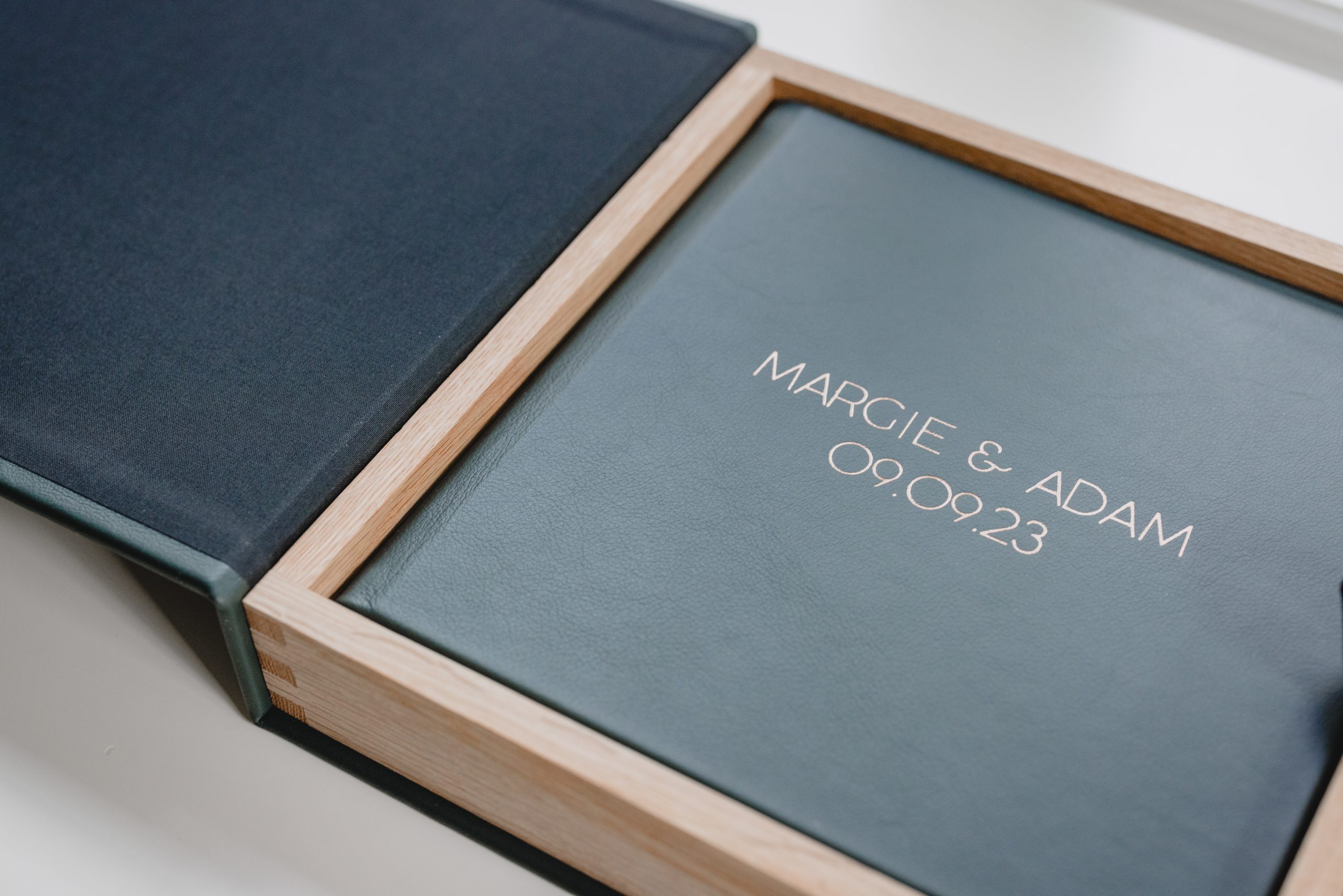 Leather wedding album in a wooden box engraved with couple’s names, crafted by a New Jersey wedding photographer.