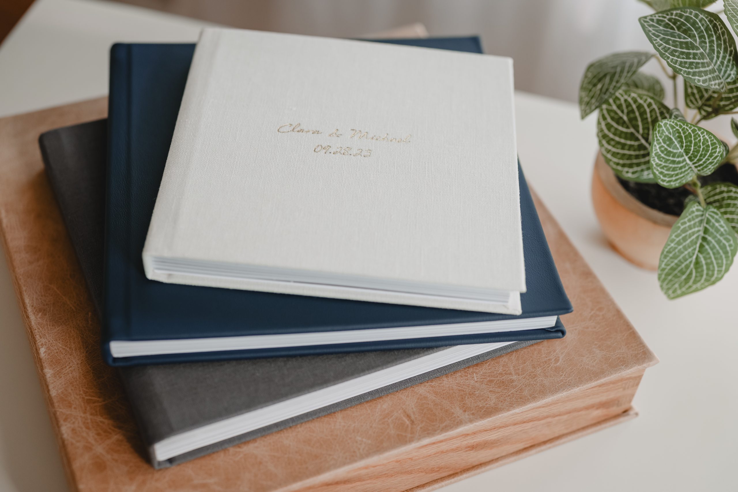 Stack of elegant wedding albums with custom covers, designed by a New Jersey wedding photographer.