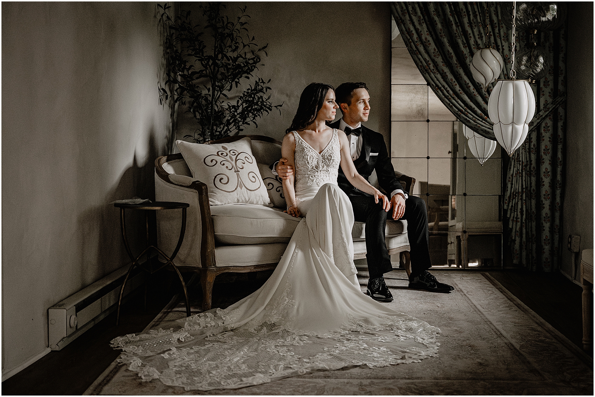 Couple sitting next to each other on a couch during their Summer Crossed Keys Estate wedding.