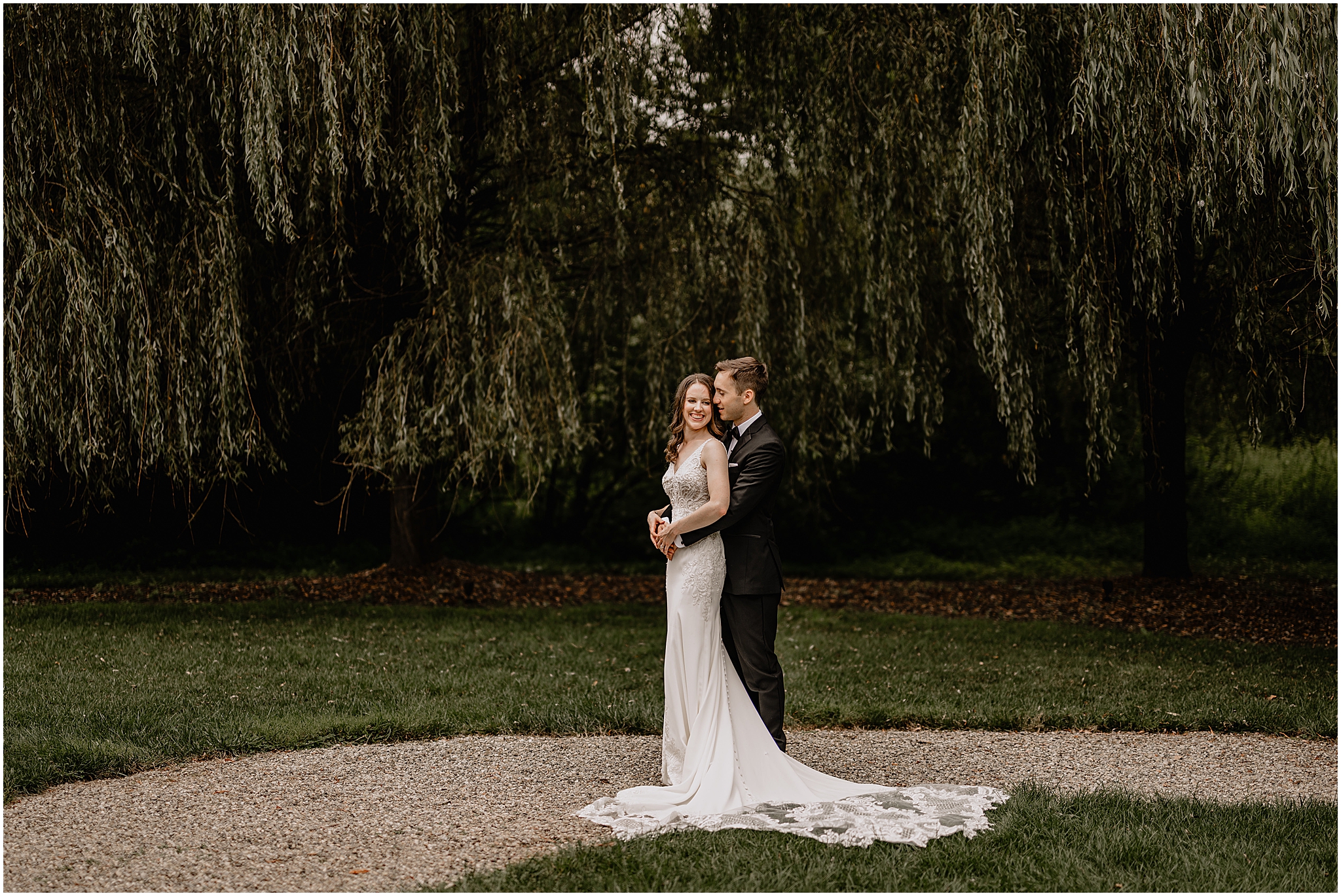 Groom hugging the bride from behind during their Summer Crossed Keys wedding.