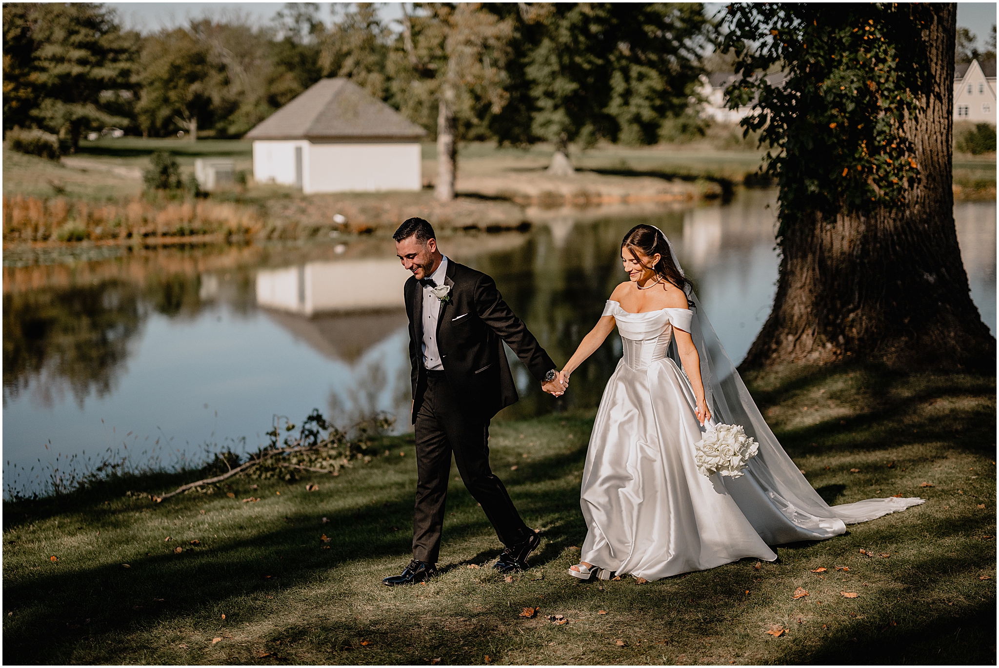 Bride and groom walking hand in hand in the sunlight during their Tillinghouse Wedding portraits.