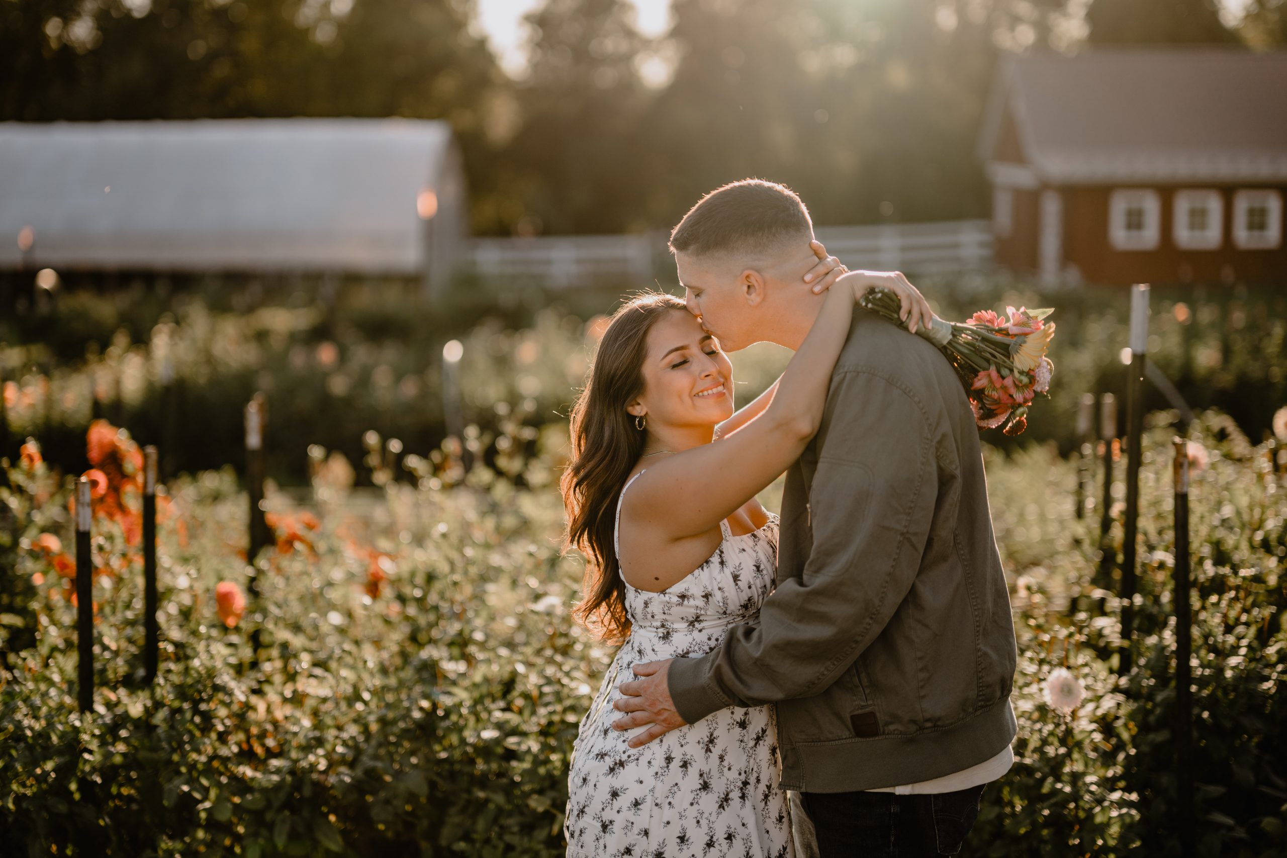 Jennifer and Anthony sharing a sweet moment in the flower fields during their engagement at Blue Bird Alpaca Farm.